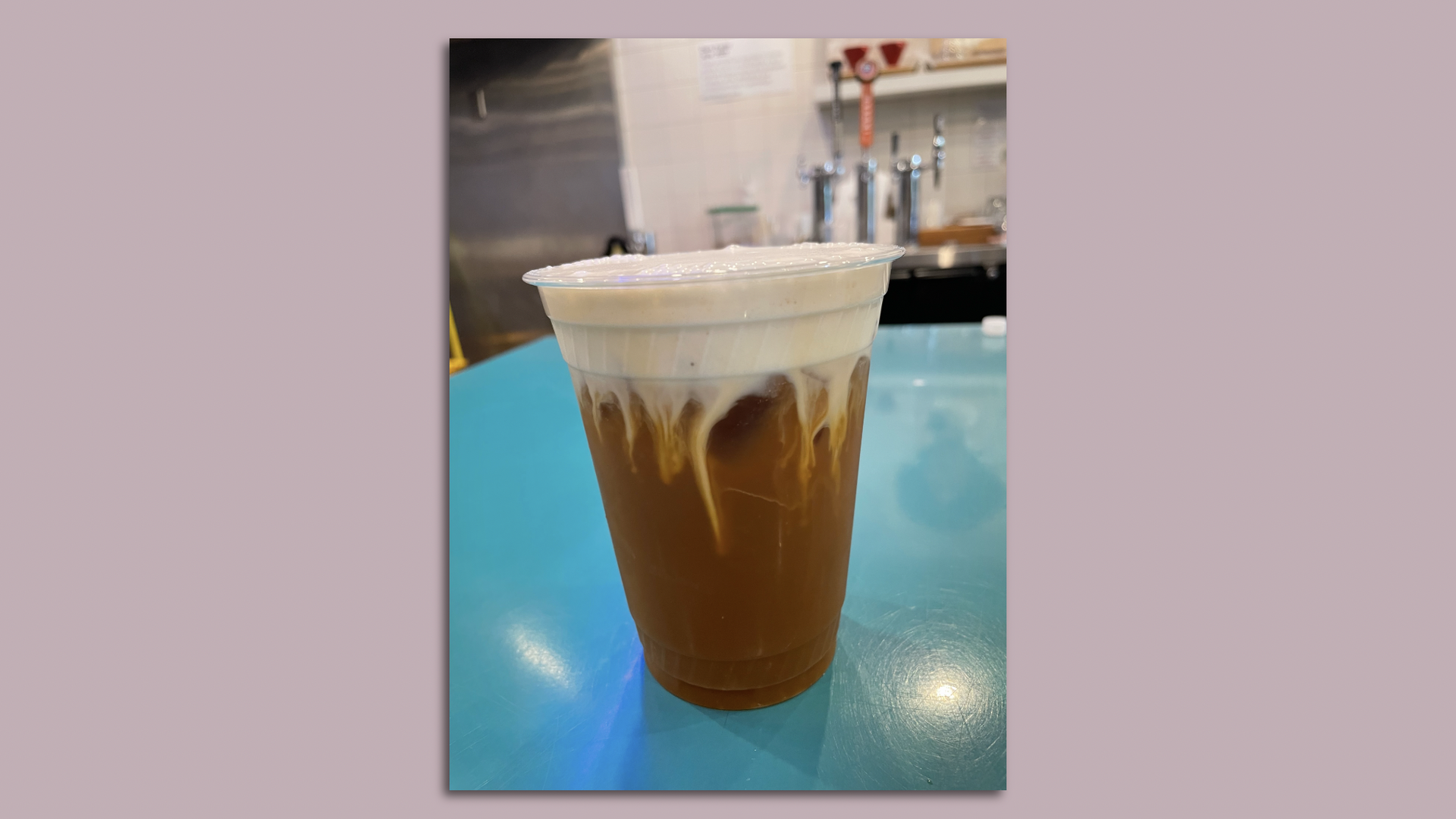 cold brew with banana foam on a blue table