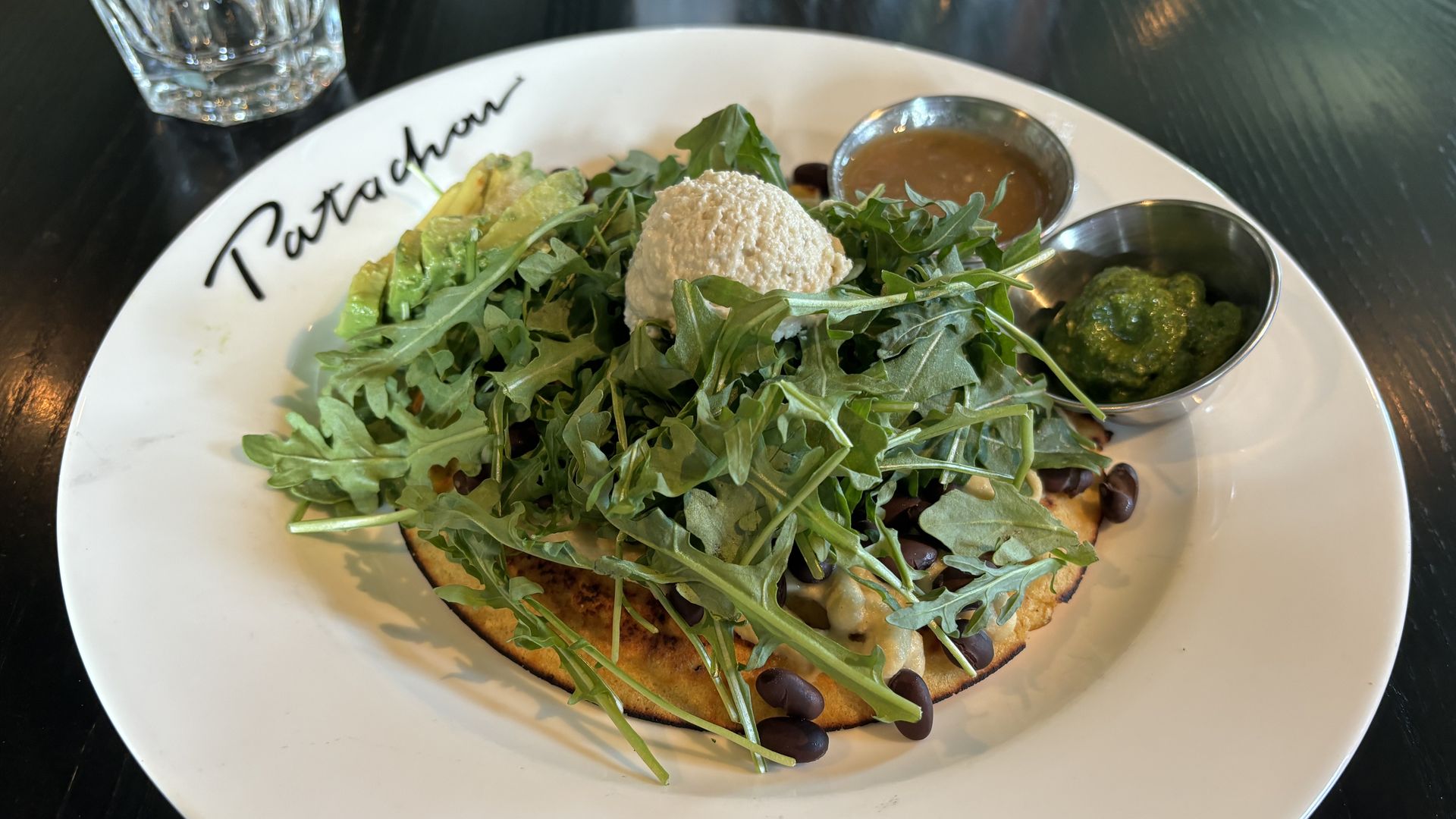 A white plate with food and greens