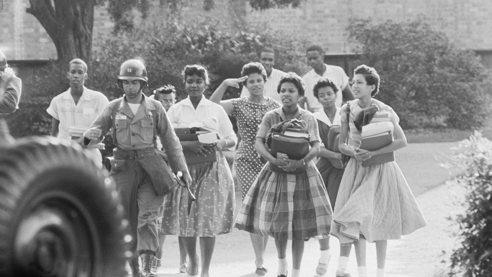 A photo of the Little Rock Nine being escorted by federal troops after school. 