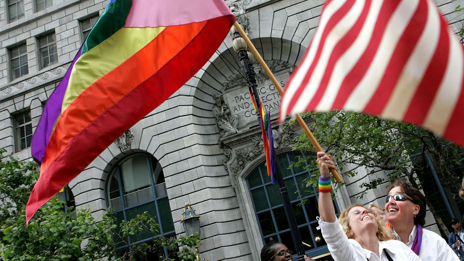  Kimberly Laird (L) and her partner Glenne McElihinndy wave a pride flag before the start of the 2005 San Francisco Pride Parade 