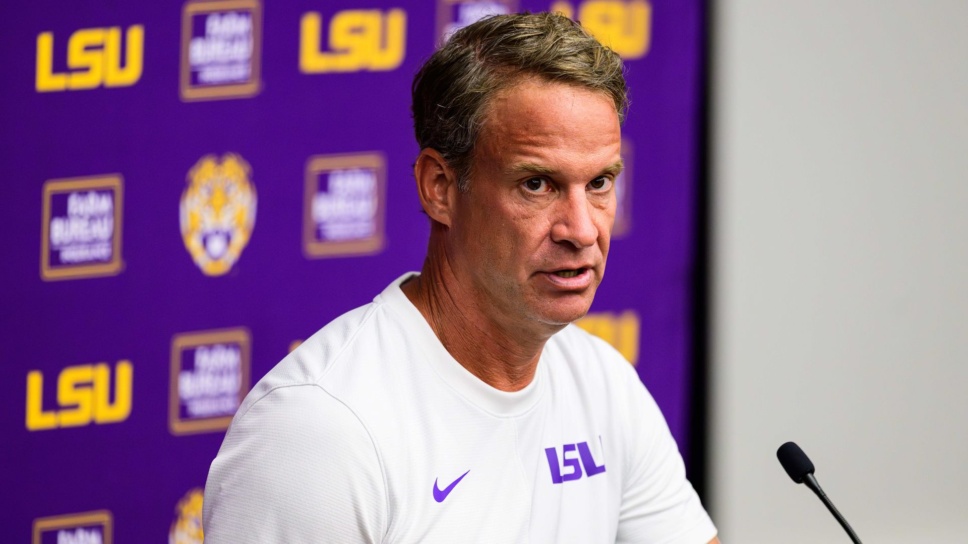 Photo shows a headshot of Lane Kiffin talking.