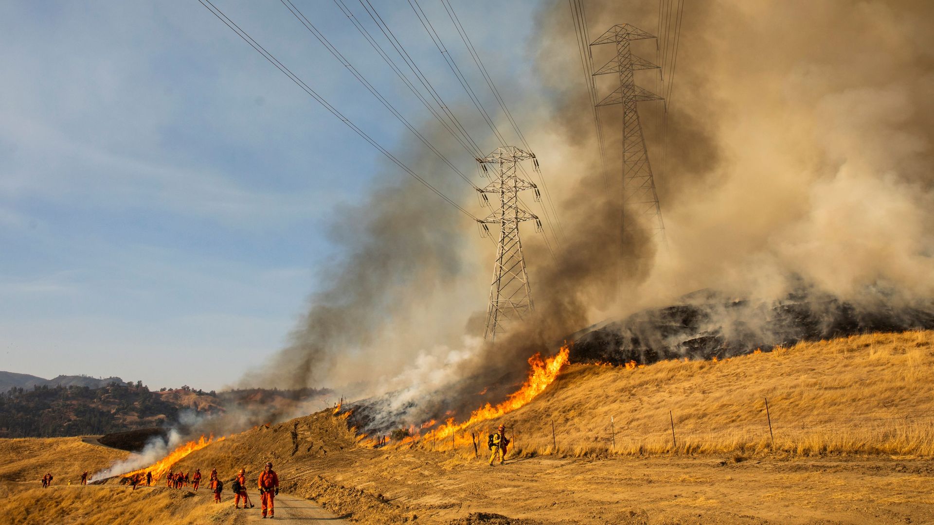  A back fire set by fire fighters burns a hillside near PG&E power lines during firefighting operations to battle the Kincade Fire in Healdsburg, California on October 26, 2019. 