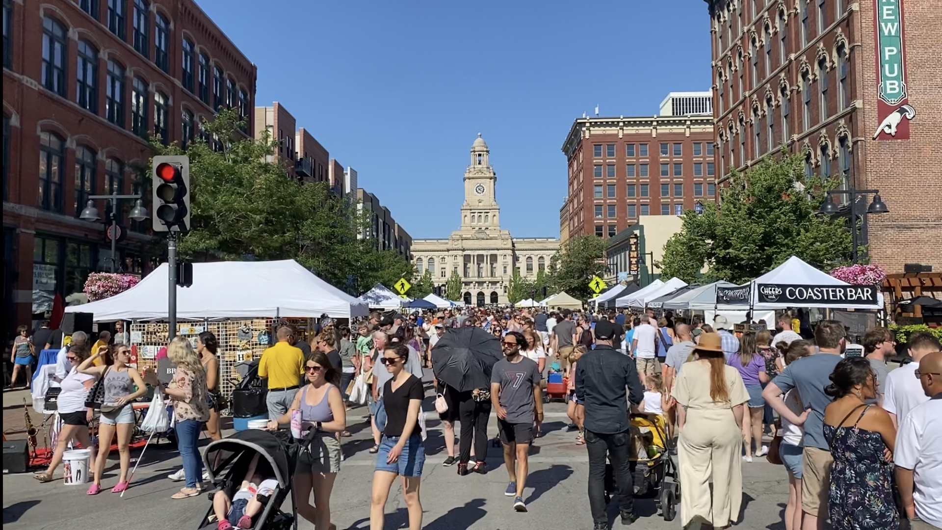 A crowd of people walking outside at the Downtown Des Moines Farmers Market.