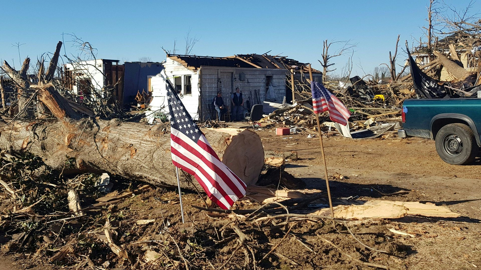 Marty James (L), 59, and a neighbor stand in front of his house in Mayfield, Kentucky, on December 12, 2021 after it was destroyed by a tornado. 