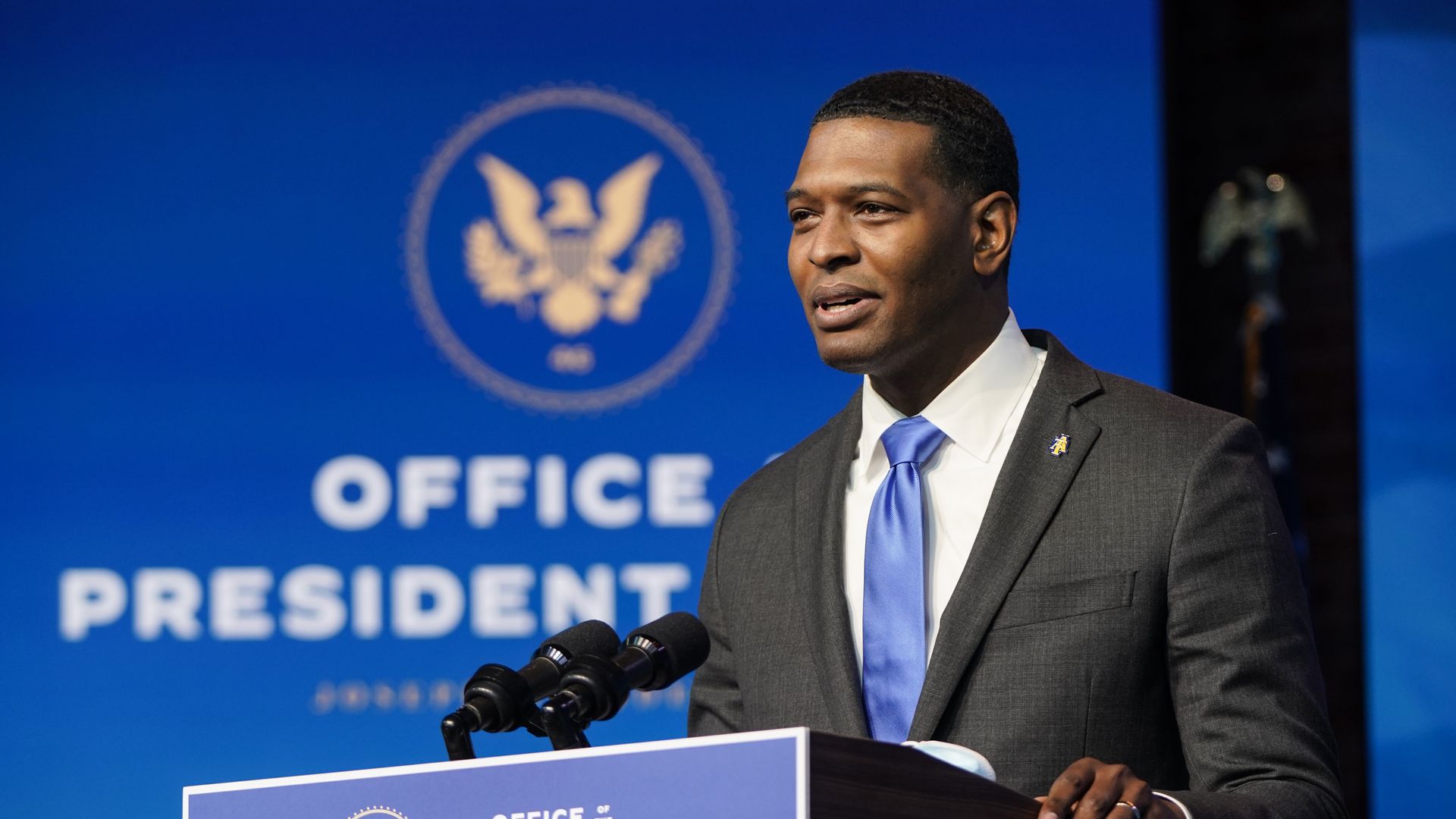 Photo of Michael Regan speaking from a podium