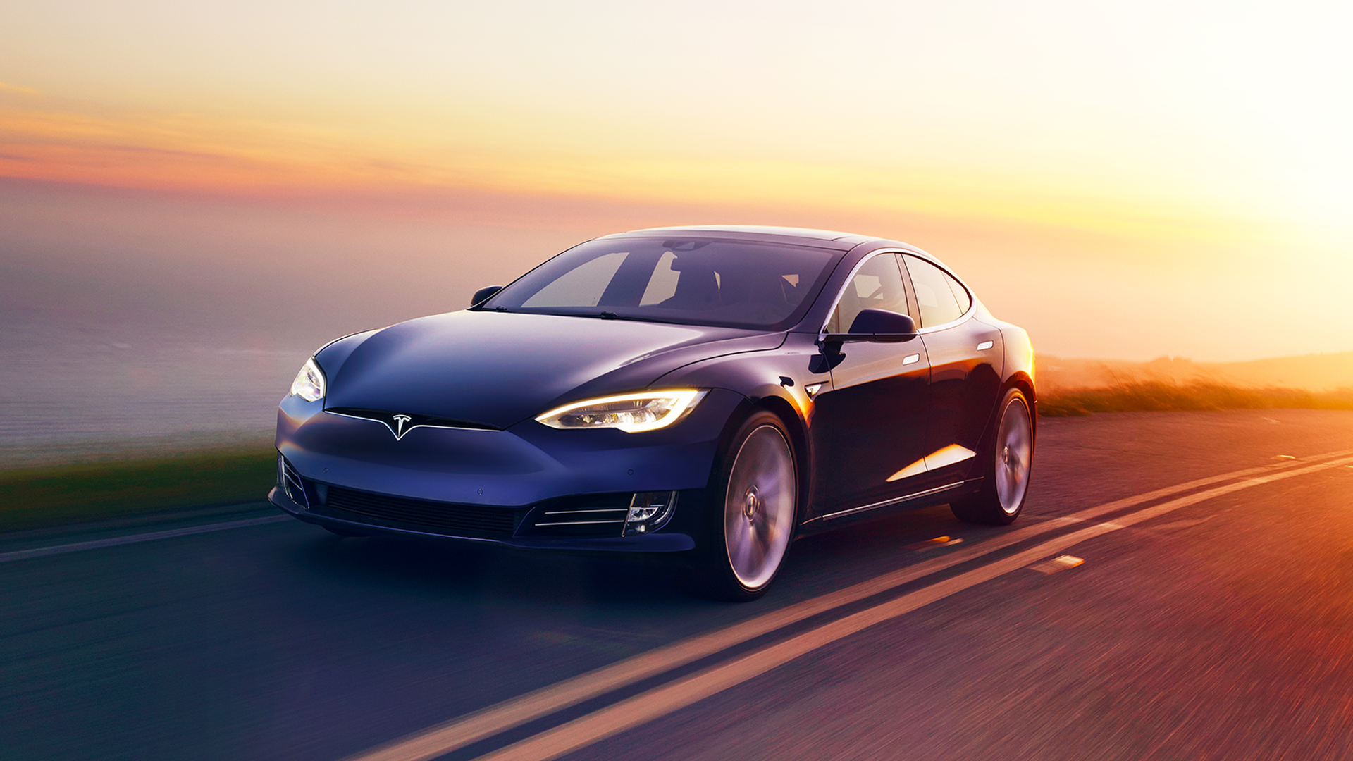 image of a a blue Tesla Model S driving away from the sunset