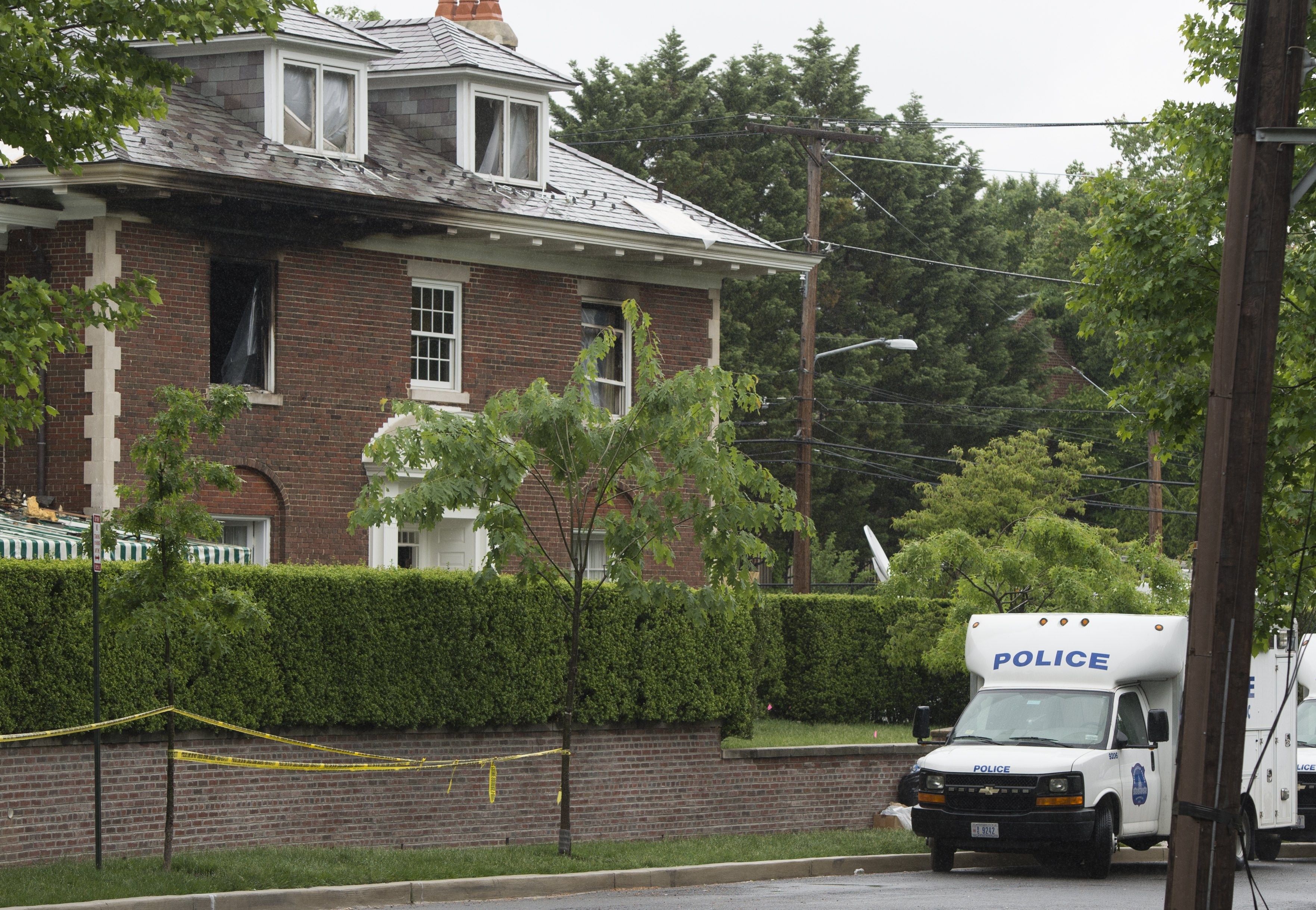 A photo showing a police van in front of a burnt brick home in Washington, D.C. 