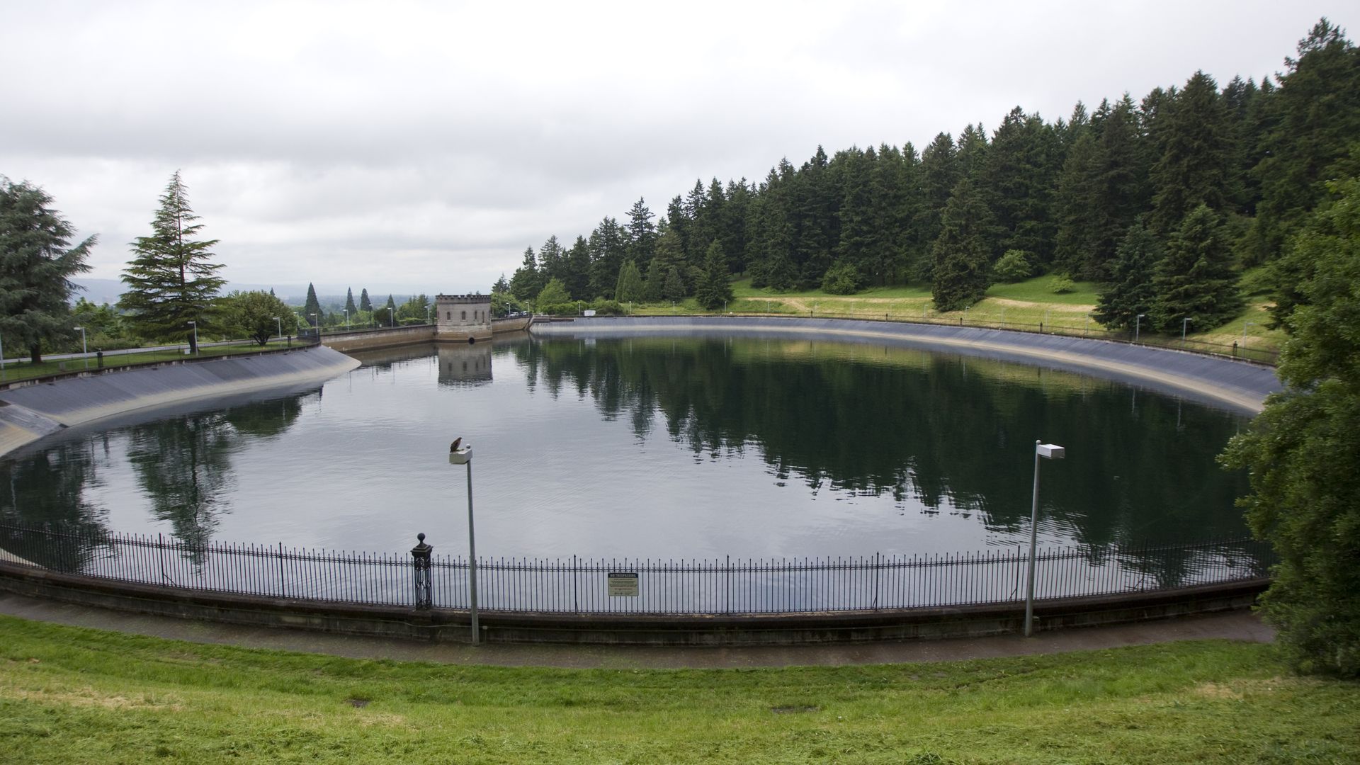 A wide shot shows a serene reservoir at Mount Tabor Park in Portland, Oregon.