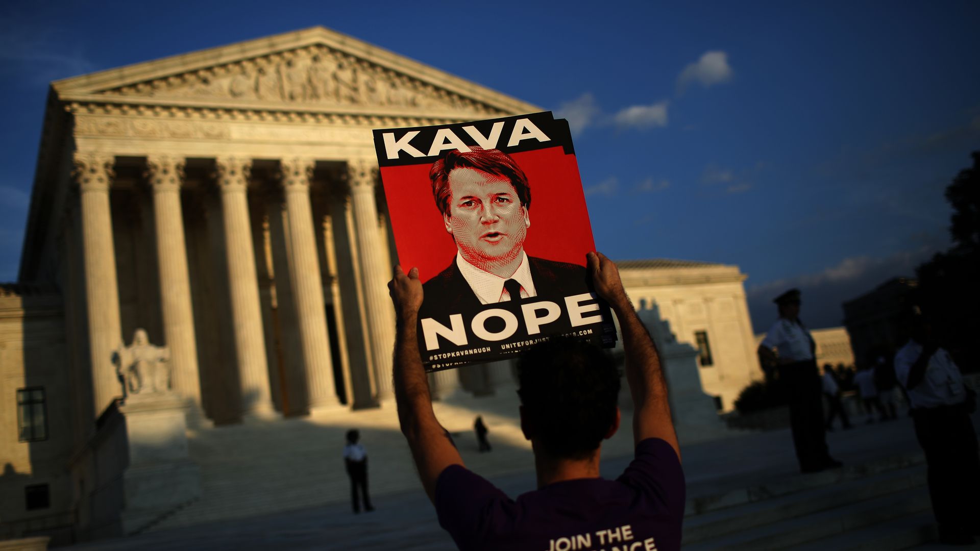 A protestor stands before the Supreme Court.