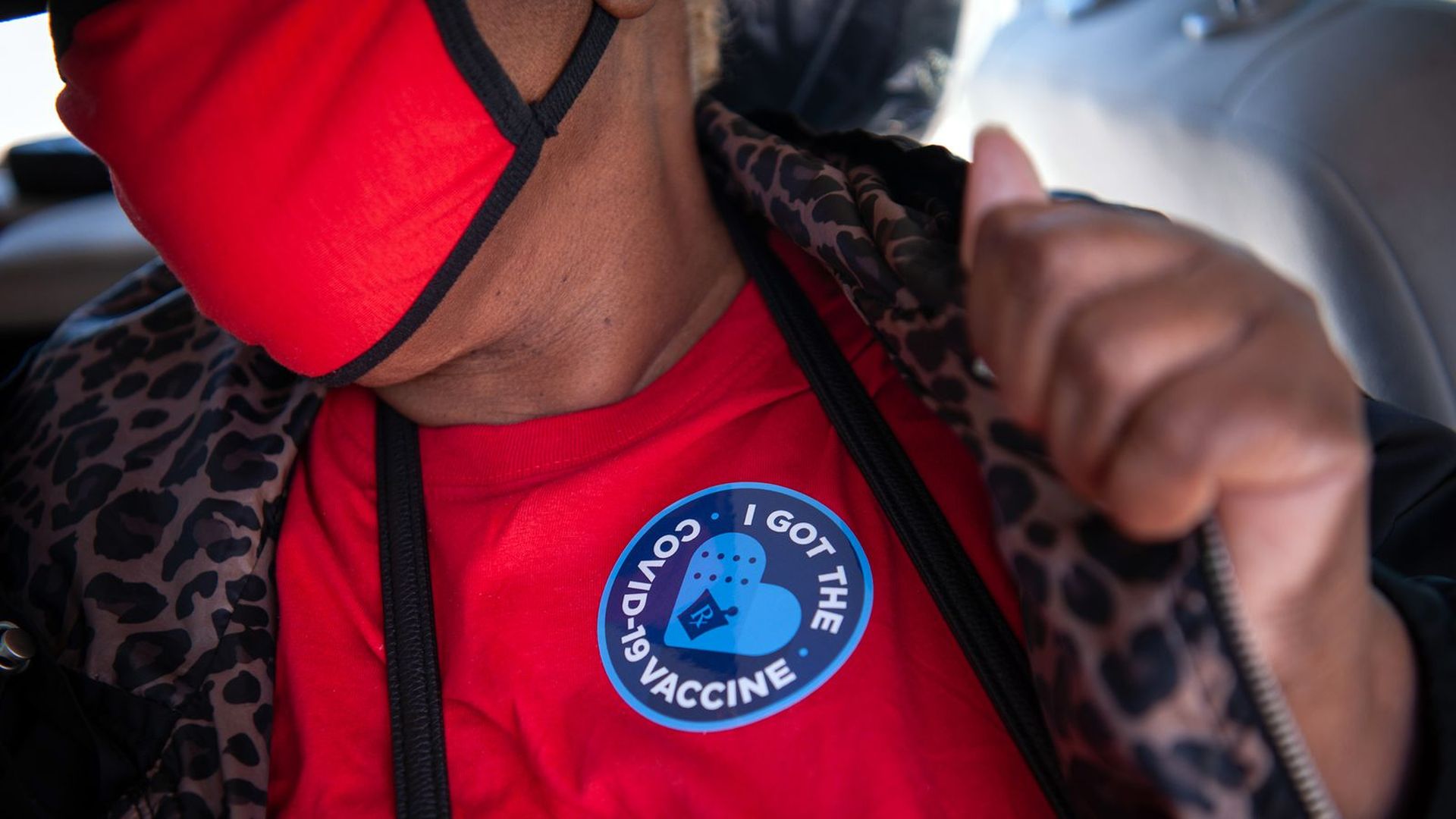 A person displays a sticker after receiving a COVID-19 vaccine at a medical clinic.