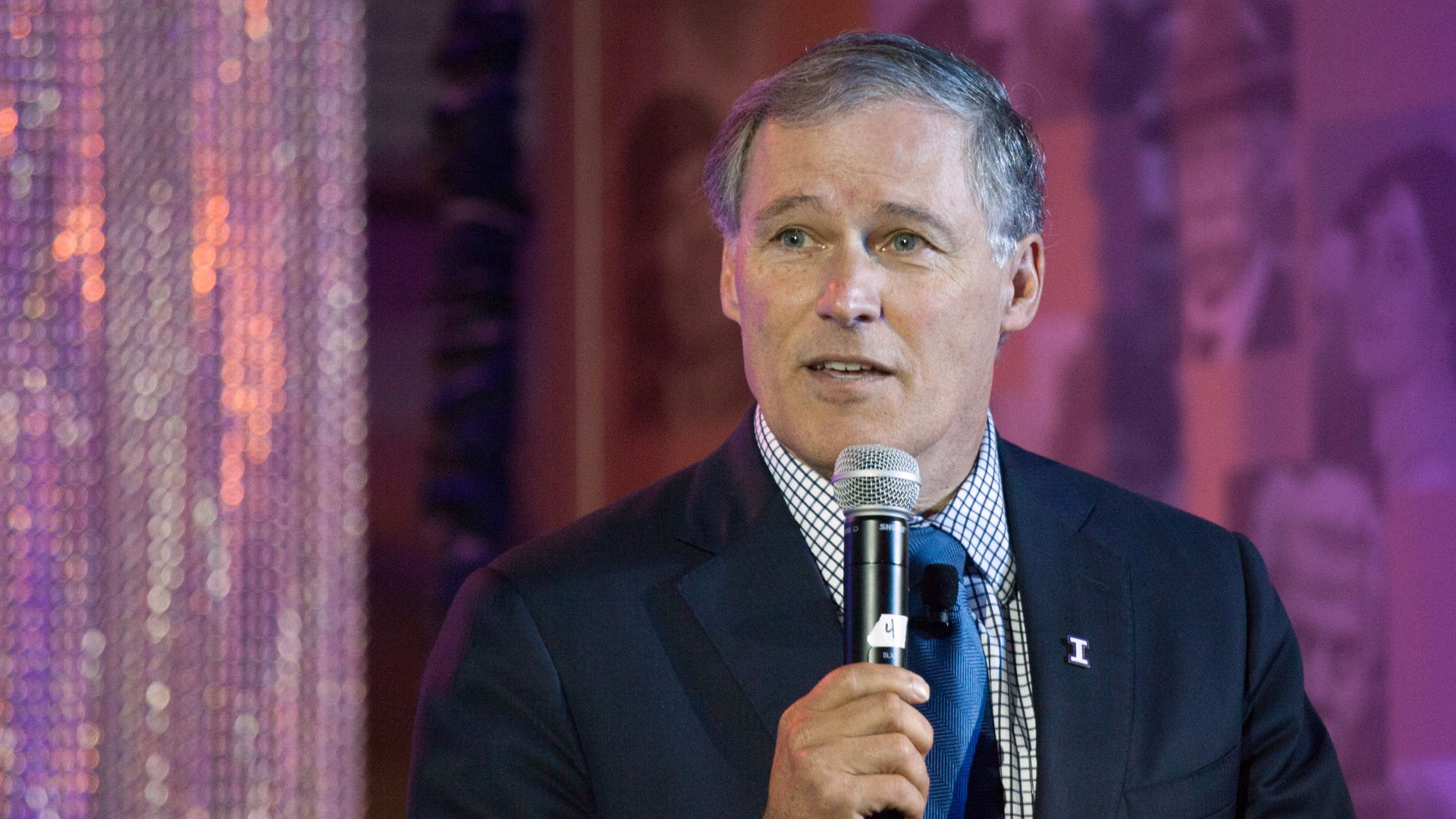 Gov. Jay Inslee holding a microphone