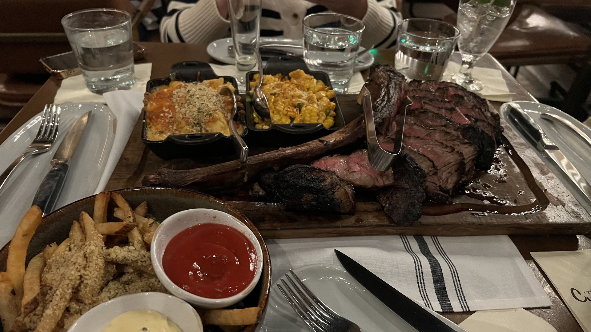 large tomahawk steak and other sides like mac and cheese and fries
