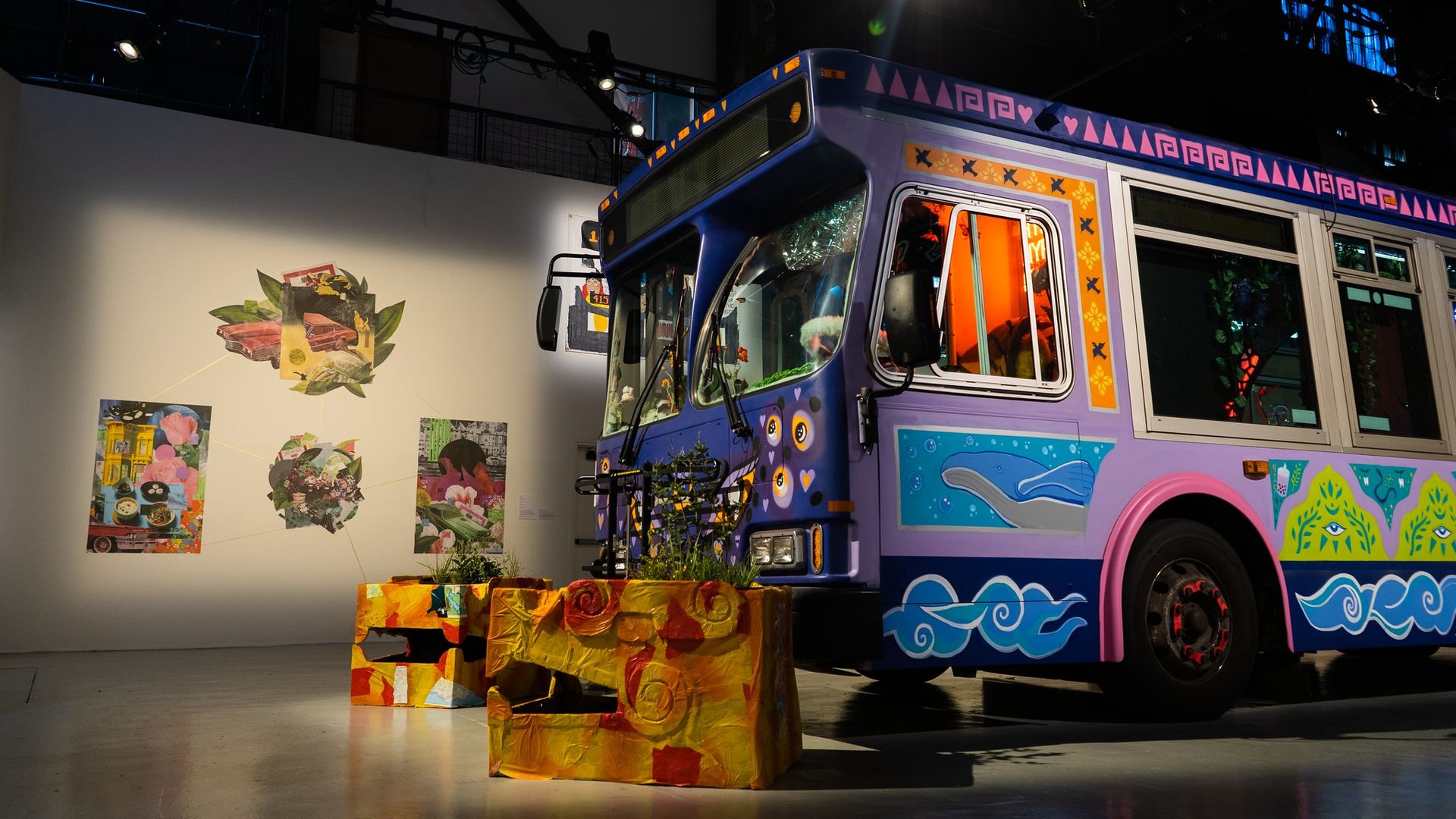 Photo of a Muni bus decorated in vibrant color patterns as it's parked in an art museum space