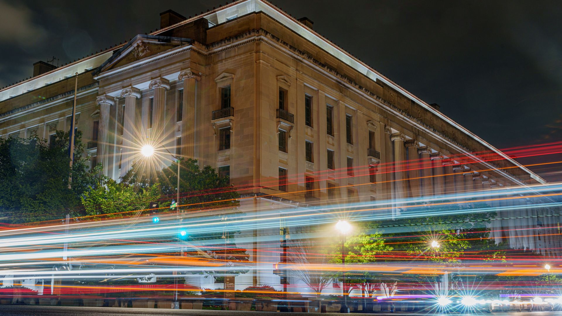 A long exposure photographer showing traffic in front of the Department of Justice building