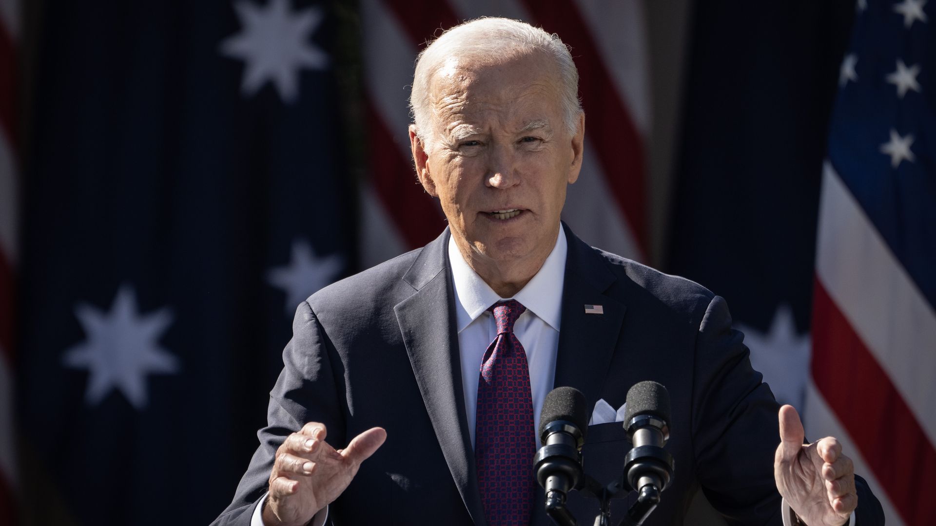 President Biden speaks behind a podium outside the White House.