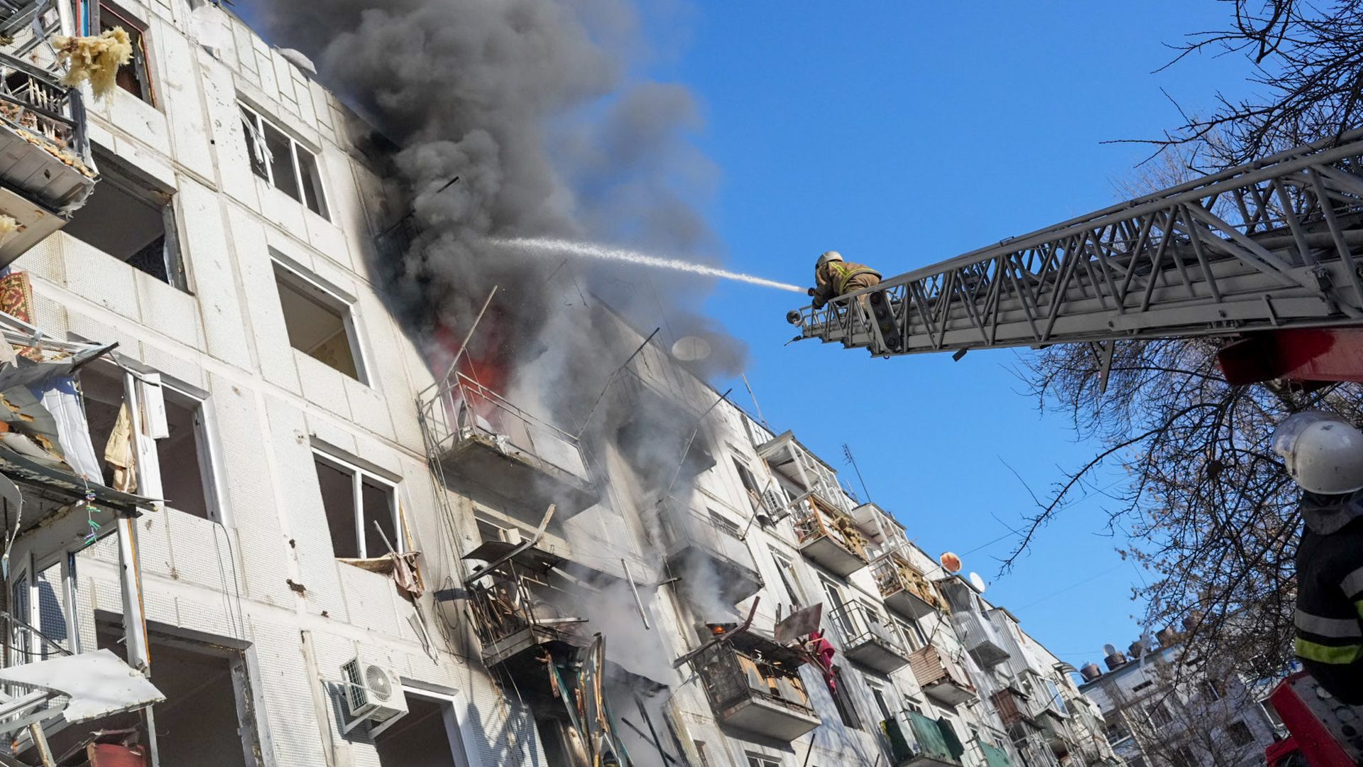 Ukrainian firefighters try to extinguish a fire after an airstrike hit an apartment complex in Chuhuiv, Kharkiv Oblast, Ukraine on February 24.
