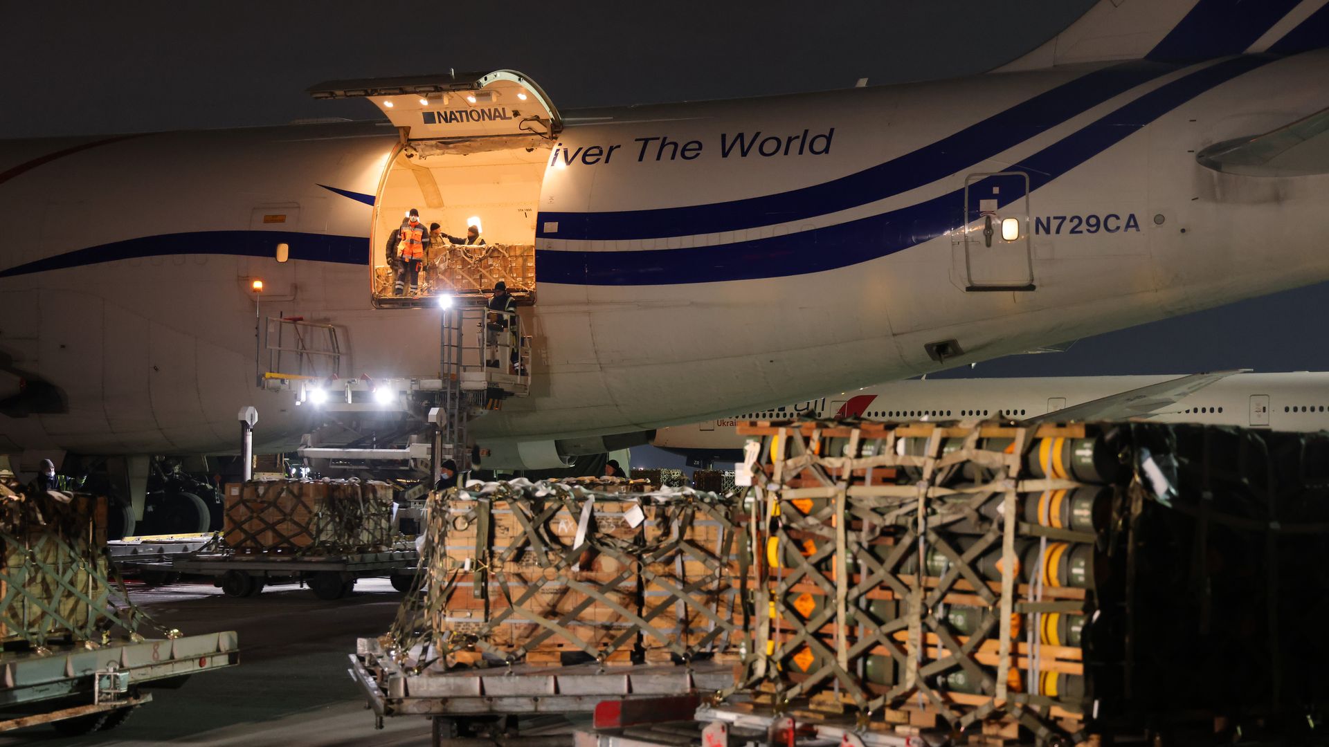 Ground personnel unload weapons and military hardware delivered to airport near Kyiv