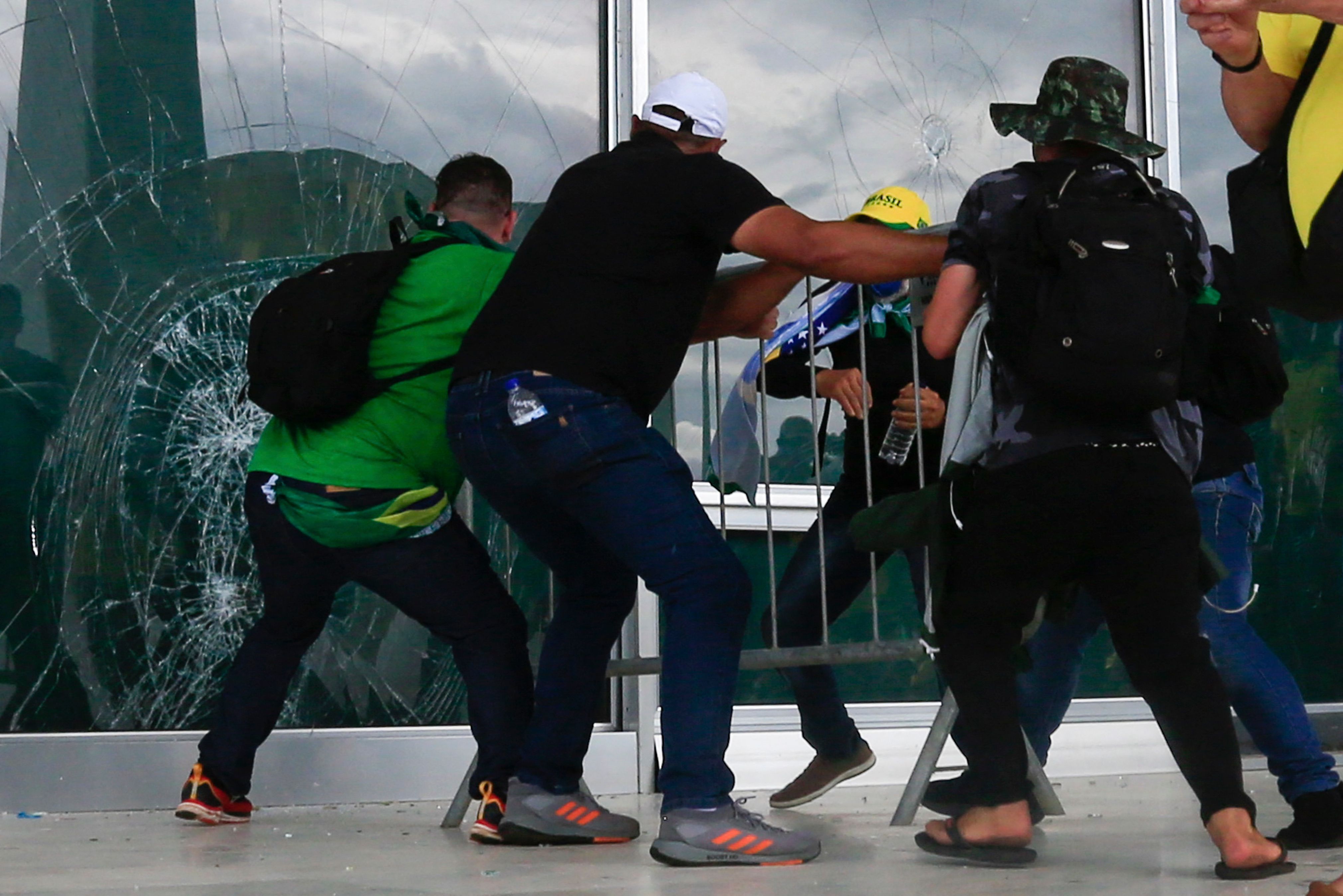 Bolsonaro supporters breaking a window as they invade the presidential palace in Brasilia on Jan. 8.