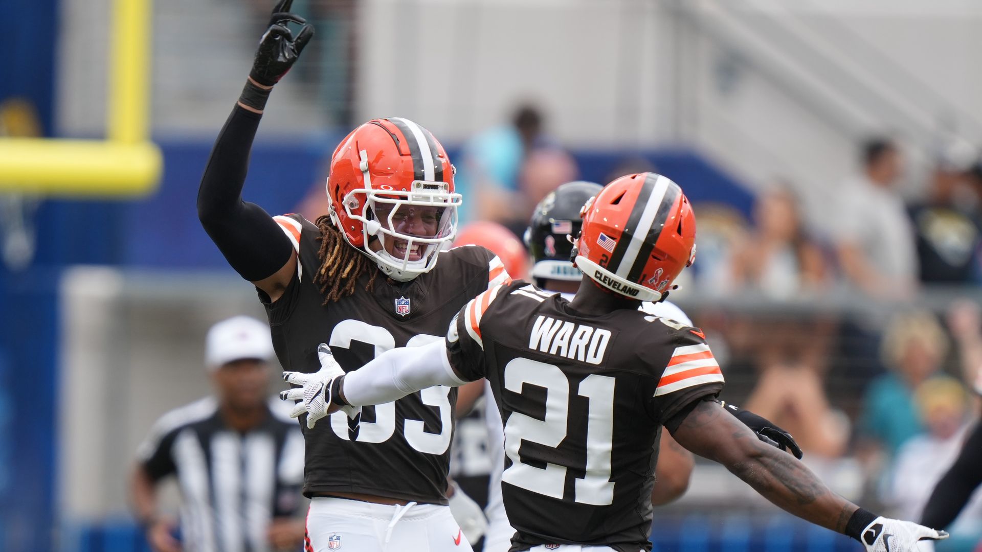 Two Cleveland Browns players celebrate after a play. 