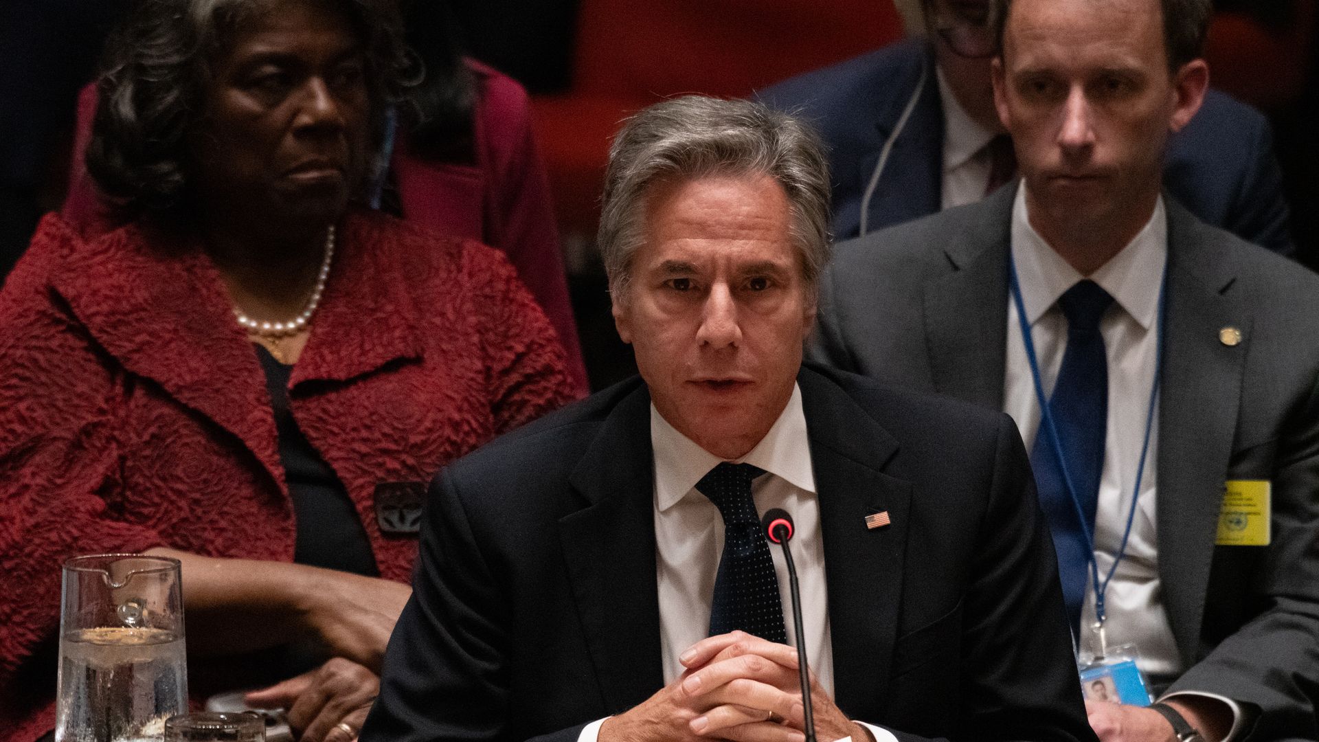 Antony Blinken speaks at a microphone seated 