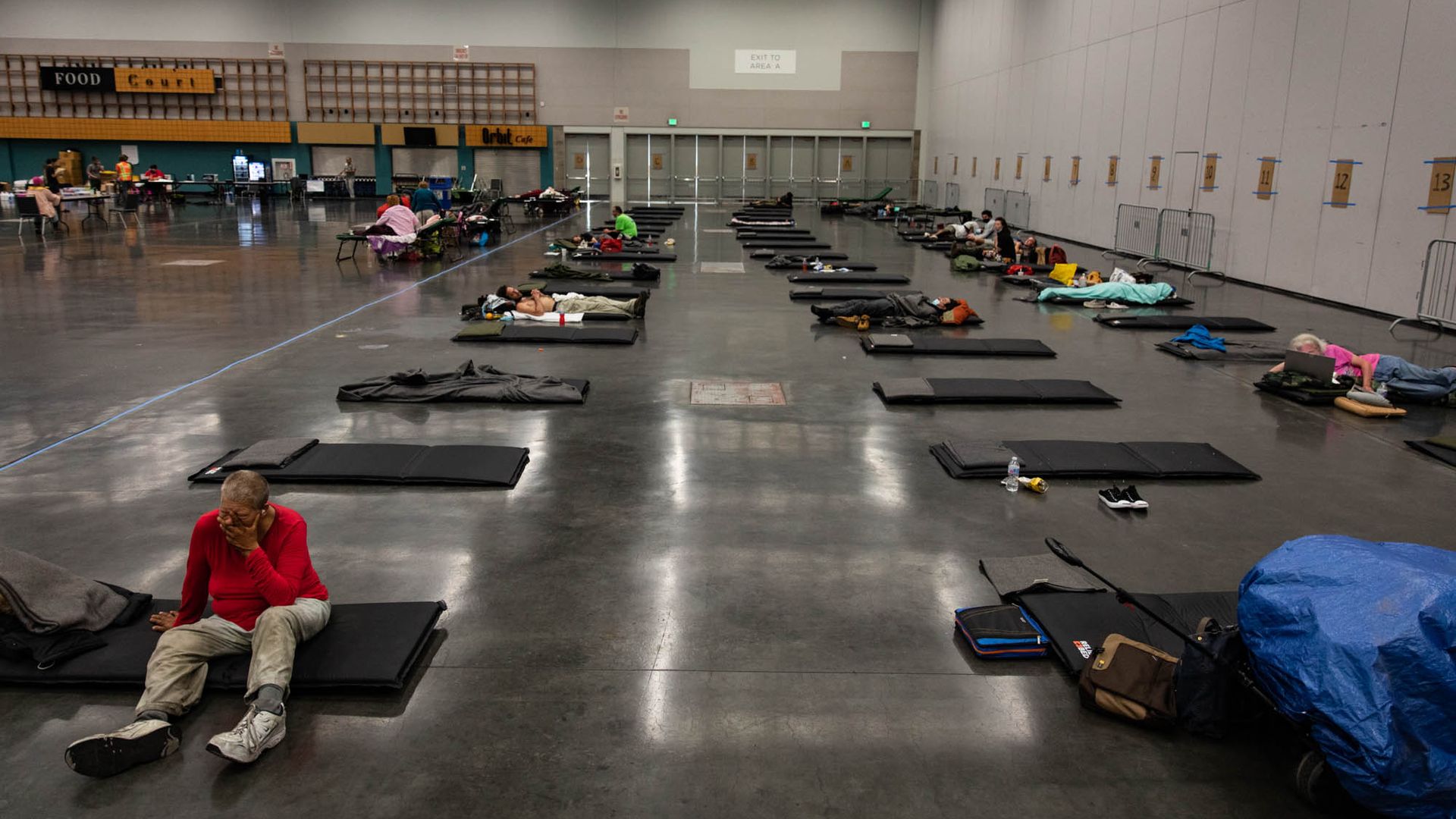 People lying on the floor of a convention center, trying to keep cool during a heat wave in Portland, Oregon.