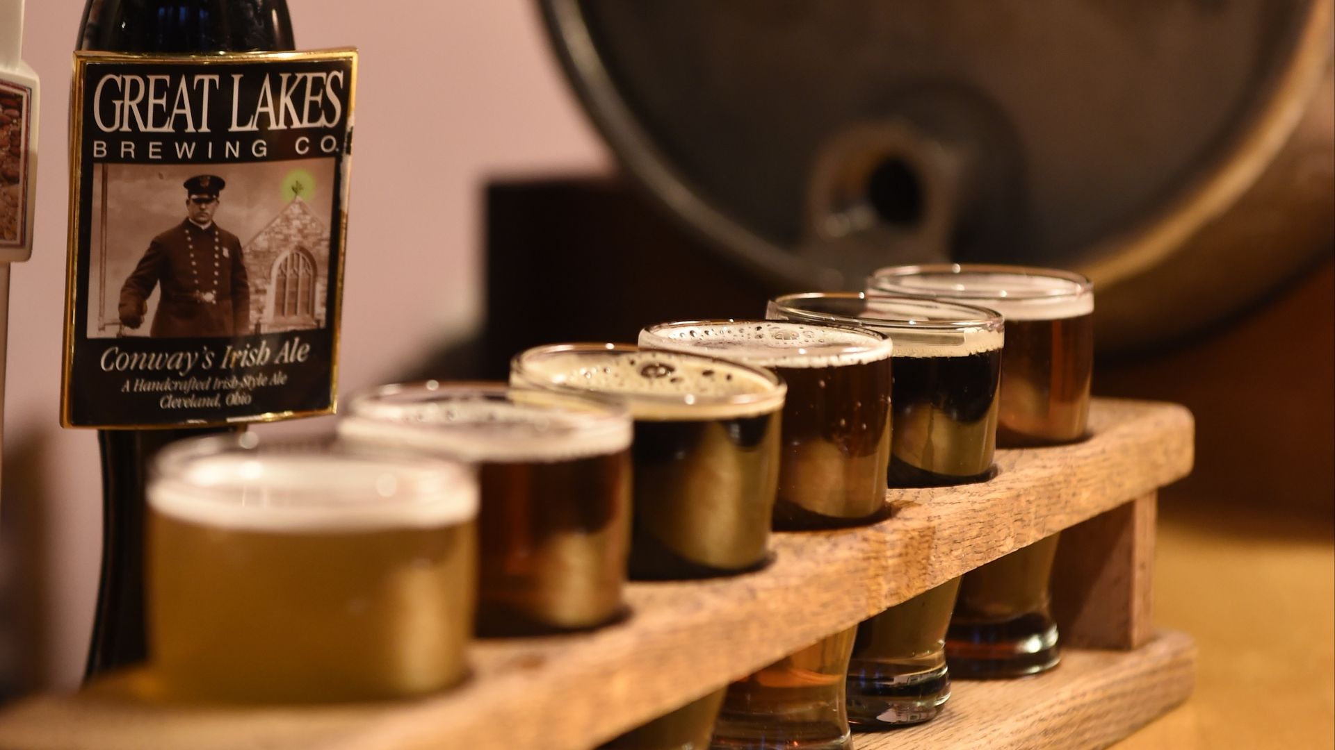 A flight of Great Lakes beer in front of a keg. 