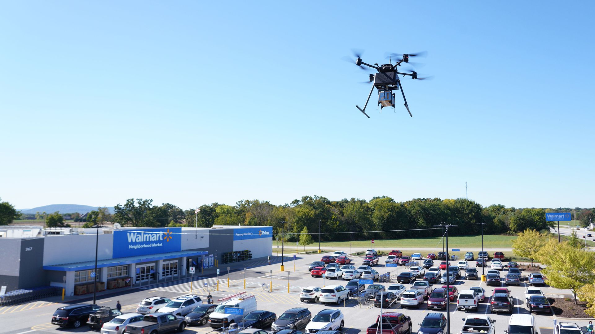 A drone flying over a Walmart parking lot.
