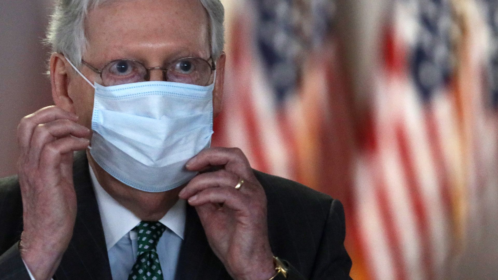 Senate Majority Leader Mitch McConnell (R-KY) puts on his face mask after speaking to members of the media following the weekly Senate Republican Policy Luncheon 