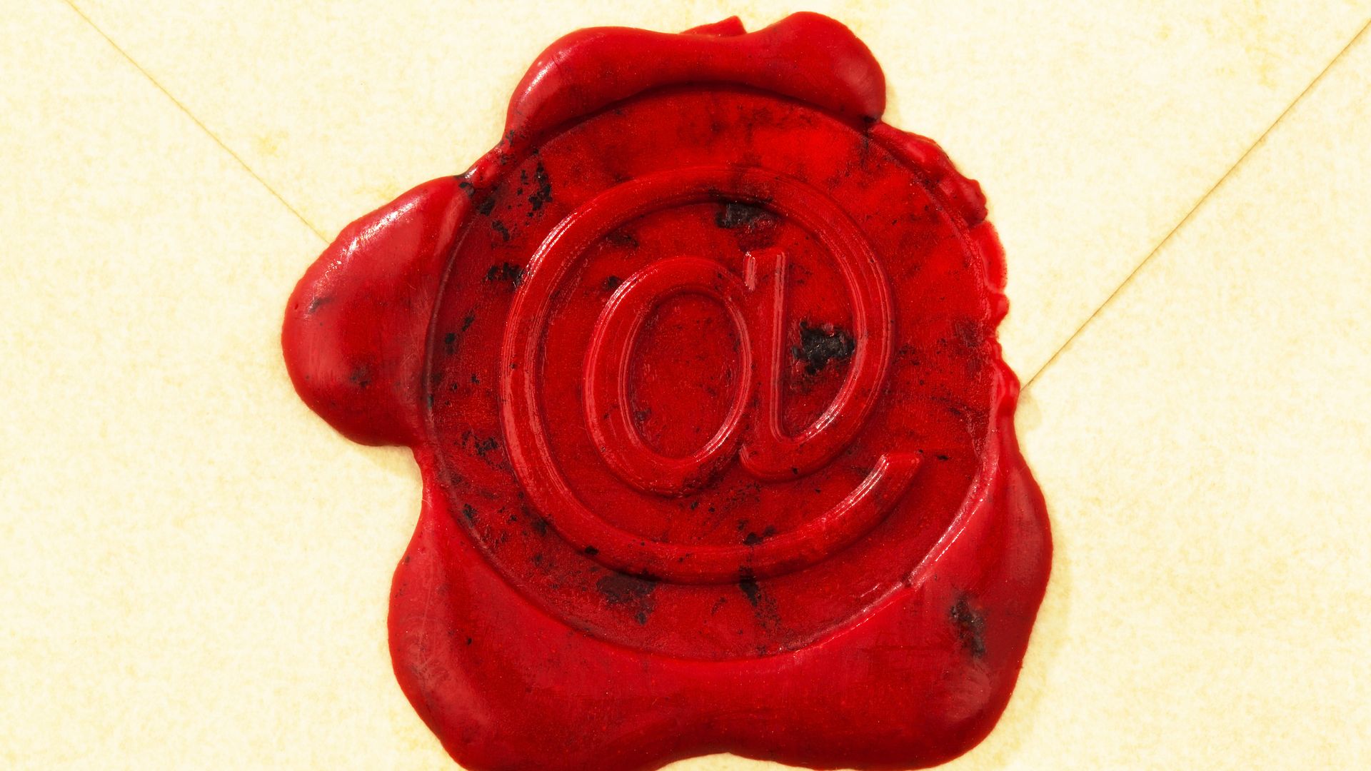 A wax seal marked with an "@" sign protects an letter. 