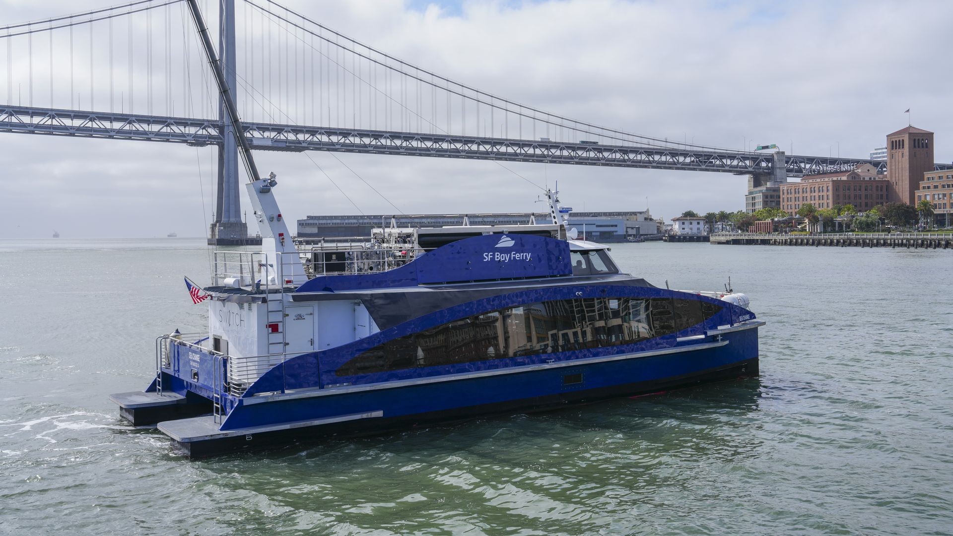 Photo of a dark blue hydrogen-powered ferry in the water