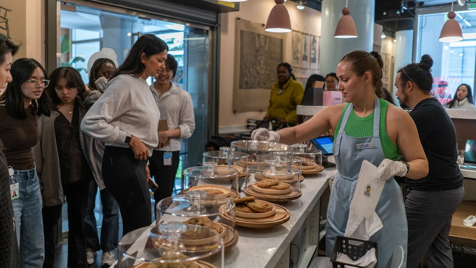 Photo of people waiting behind a counter of cookies