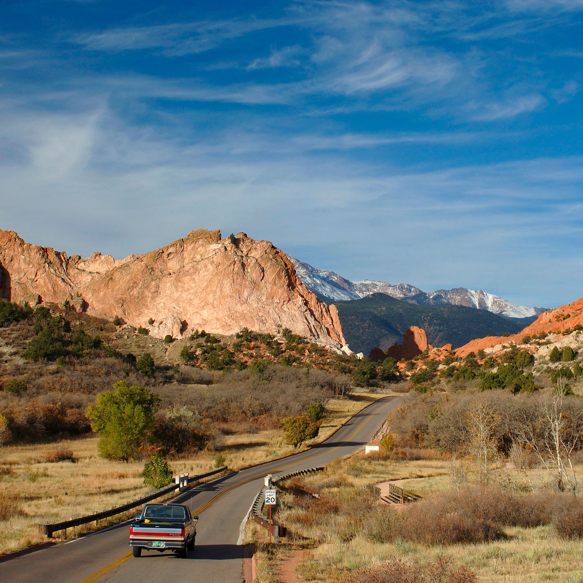 A pickup truck drives on a road near The Garden of the Gods in Colorado Springs, Colorado. 