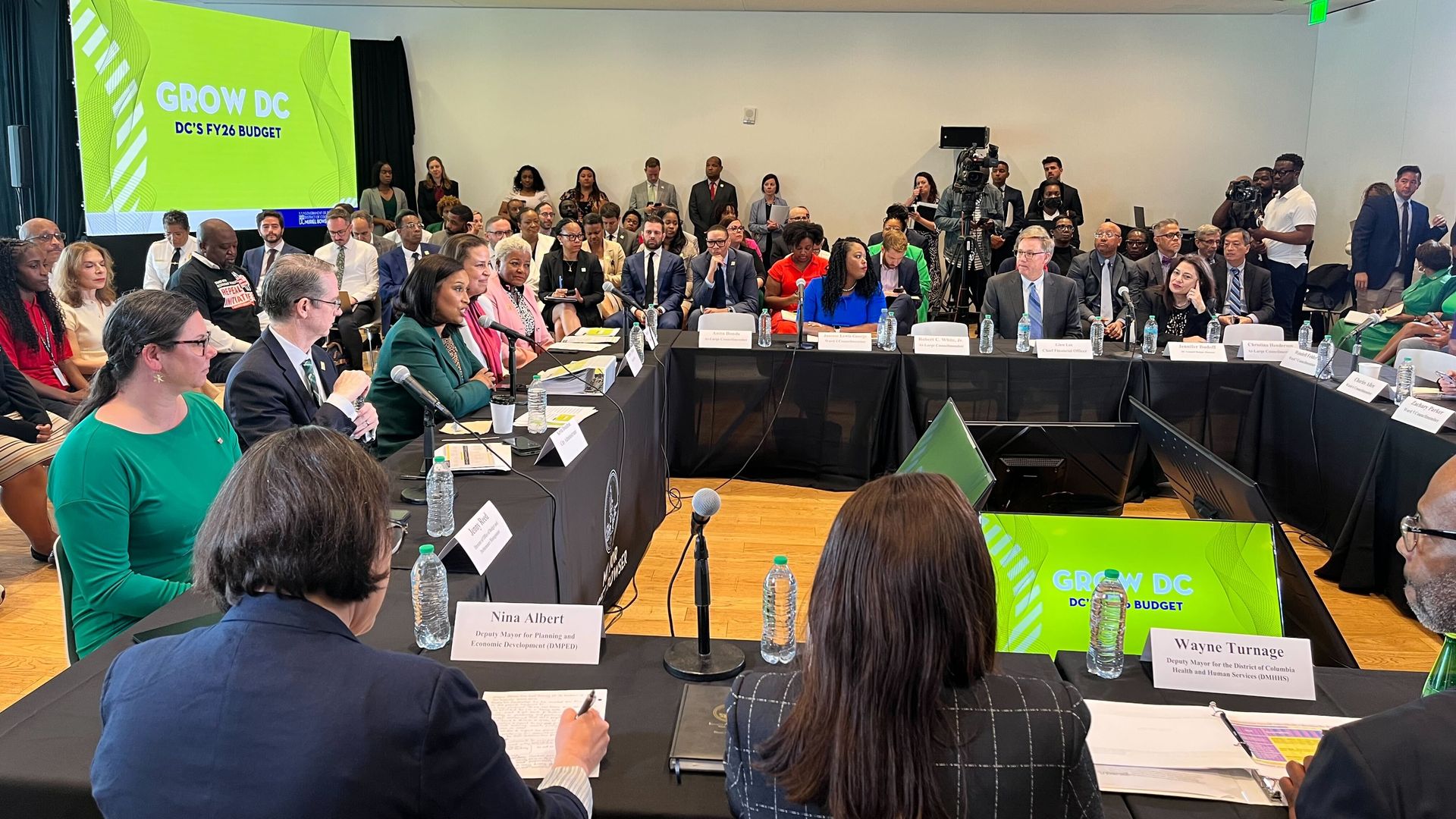 Mayor Bowser and city leaders sit around a roundtable at a budget presentation