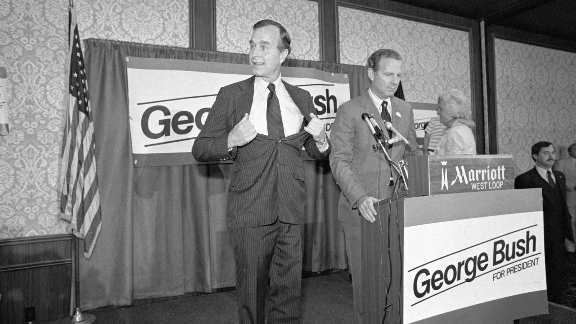 In 1980, Bush campaign manager James Baker stands at the podium while George H.W. Bush makes a joking gesture when told to loosen it up. 