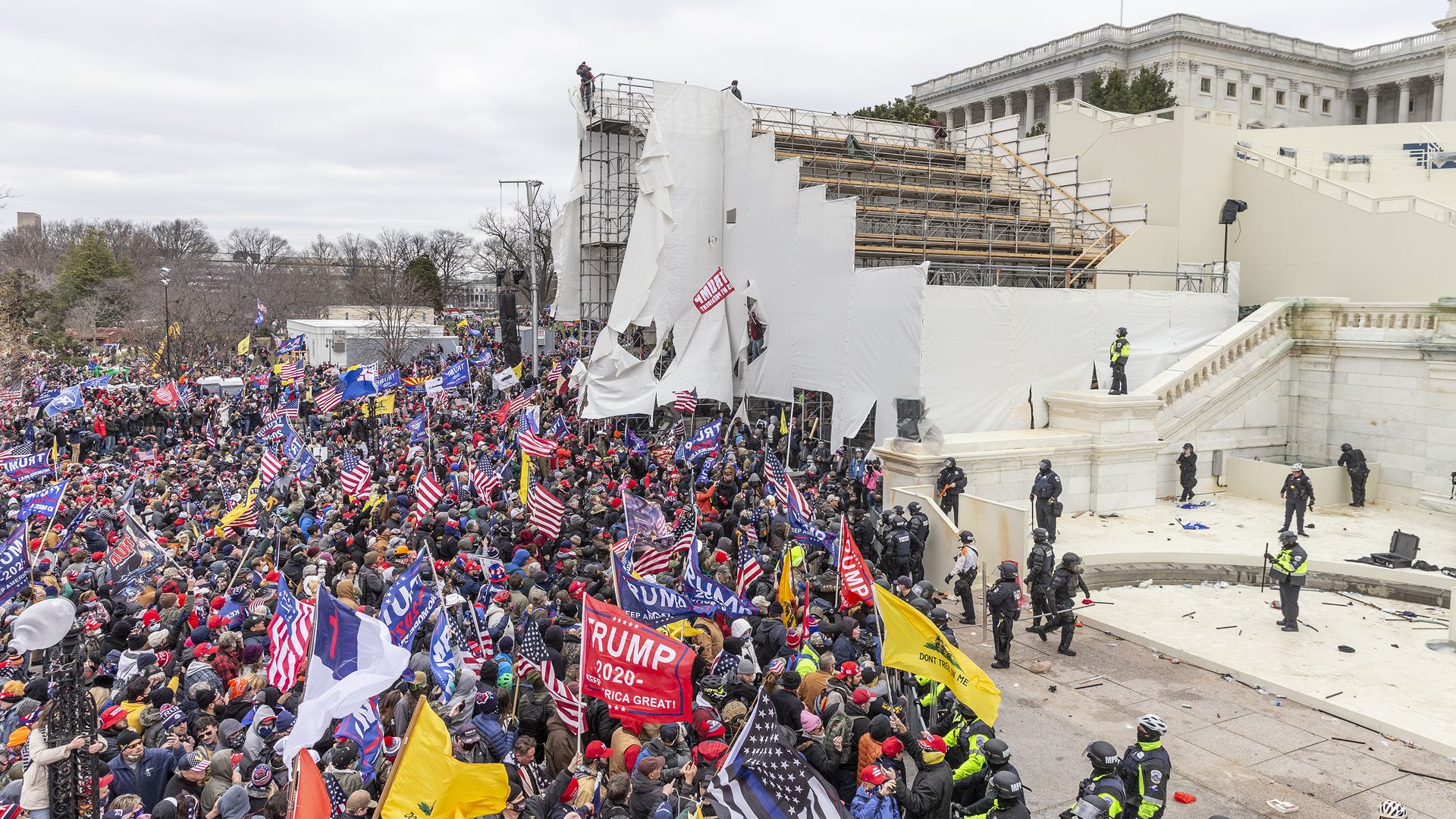 A large crowd of Trump supporters stand next to stairs leading to the U.S. Capitol