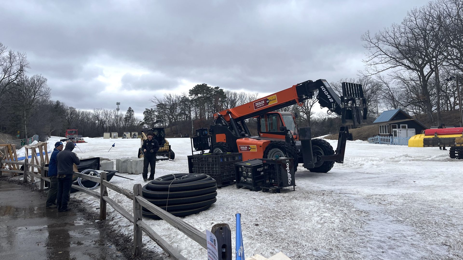 Workers stand by equipment at Wirth Park 