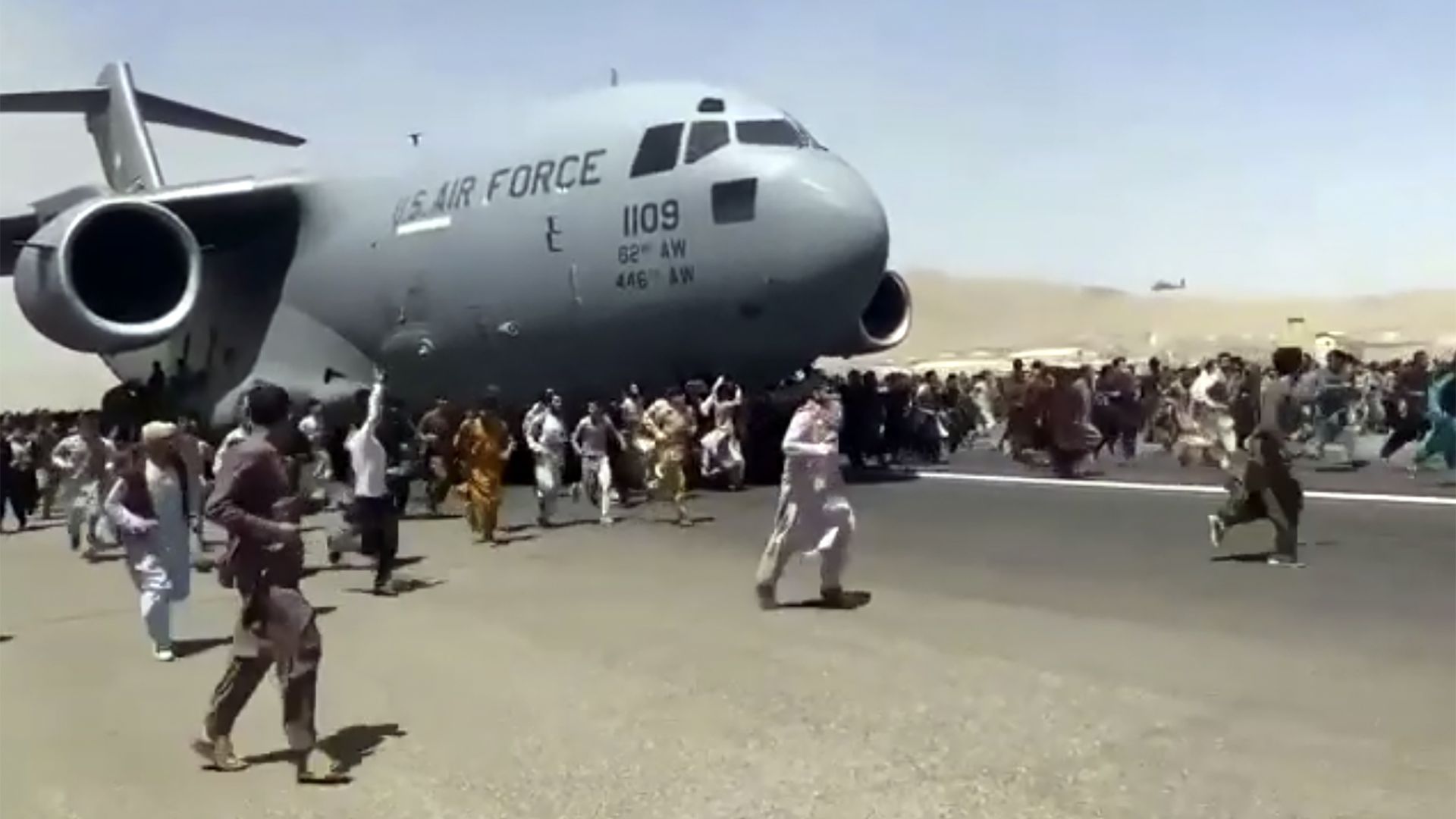 Afghans running alongside US military plane