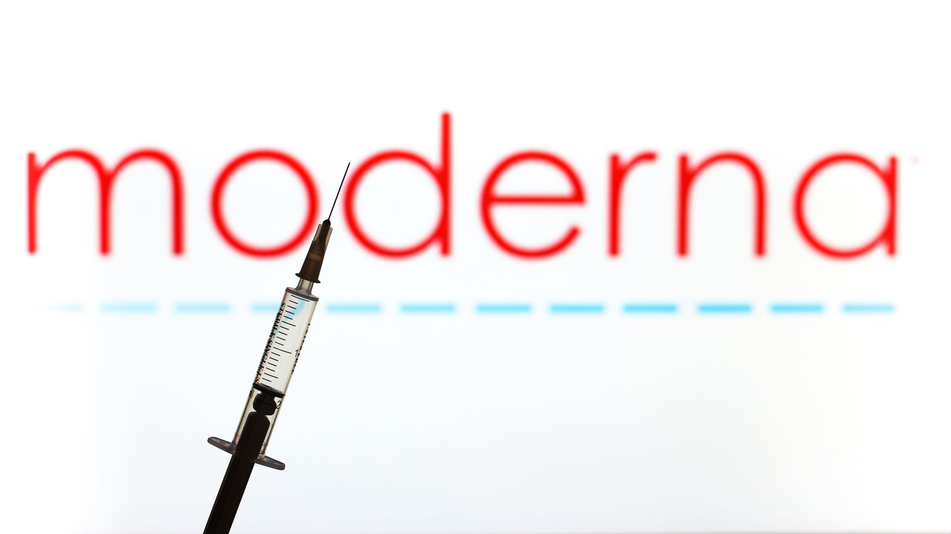 A vaccine syringe against the Moderna logo