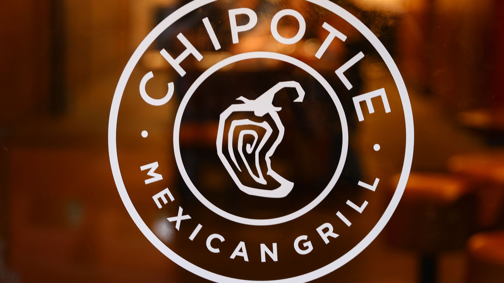 Chipotle Mexican Grill logo with a chili pepper in the middle of the circle