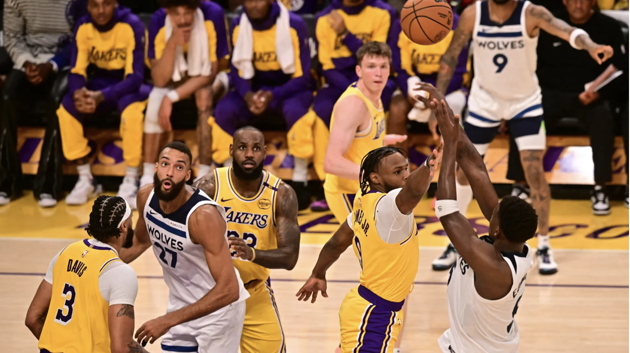 Los Angeles Lakers' small forward #23 LeBron James (C) watches as son Los Angeles Lakers' guard #09 Bronny James jumps to block a shot during their NBA game season opener against the Minnesota Timberwolves at Crypto Arena in L.A. on Tuesday, Oct. 22.
