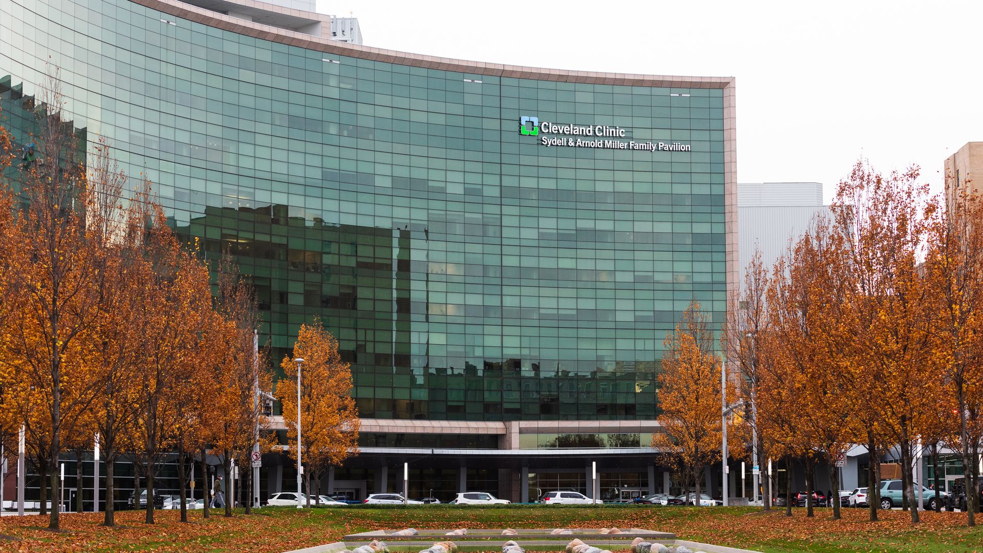 The Cleveland Clinic campus, with a glass building with the institution's name in the background, and grass and trees in the foreground.