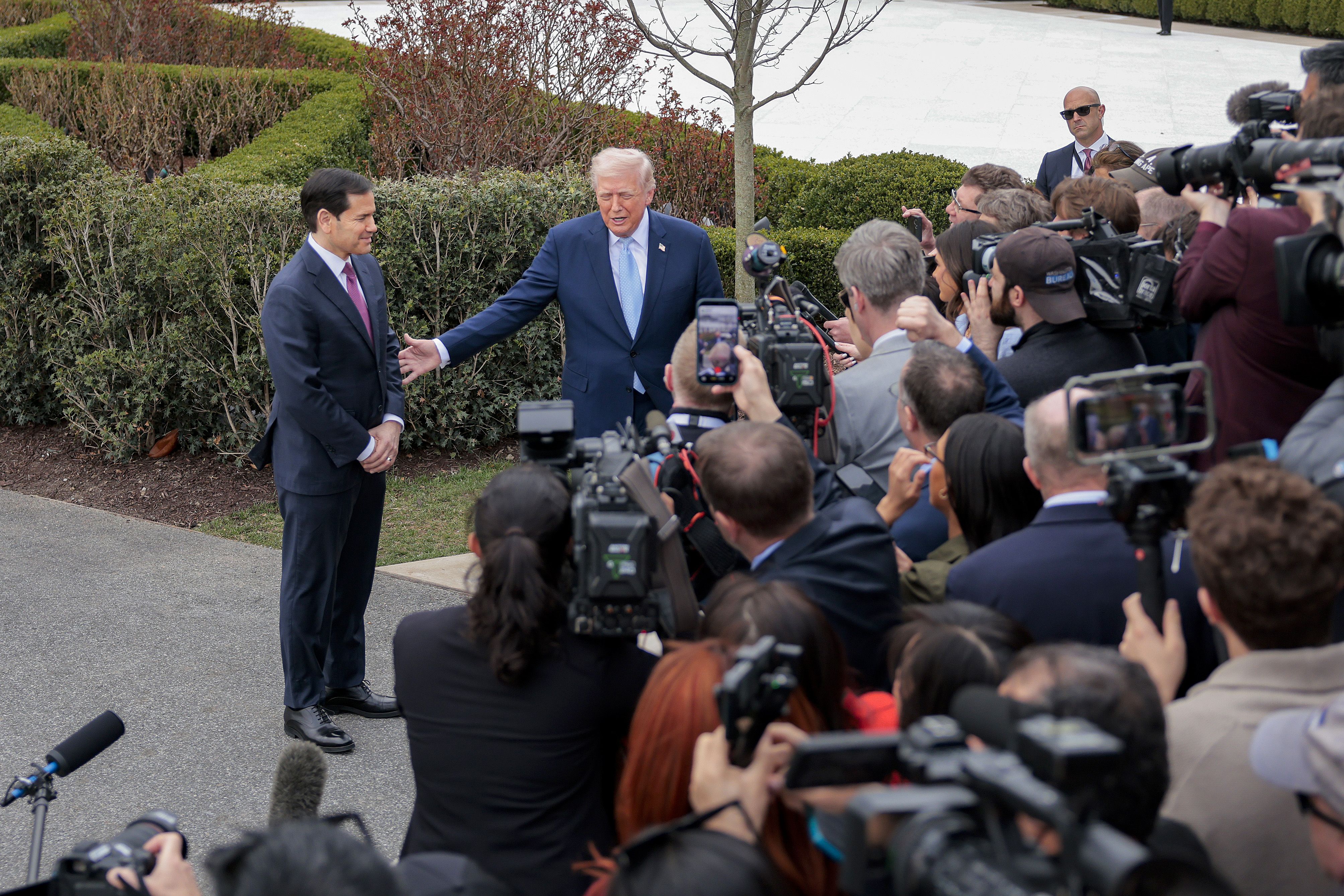 U.S. President Donald Trump gestures to U.S. Secretary of State Marco Rubio (L) as he stops to speak to reporters while departing the White House on March 20, 2026 in Washington, DC. President Trump is traveling to Florida to spend the weekend at his Mar-a-Lago resort. (Photo by Heather Diehl/Getty 
