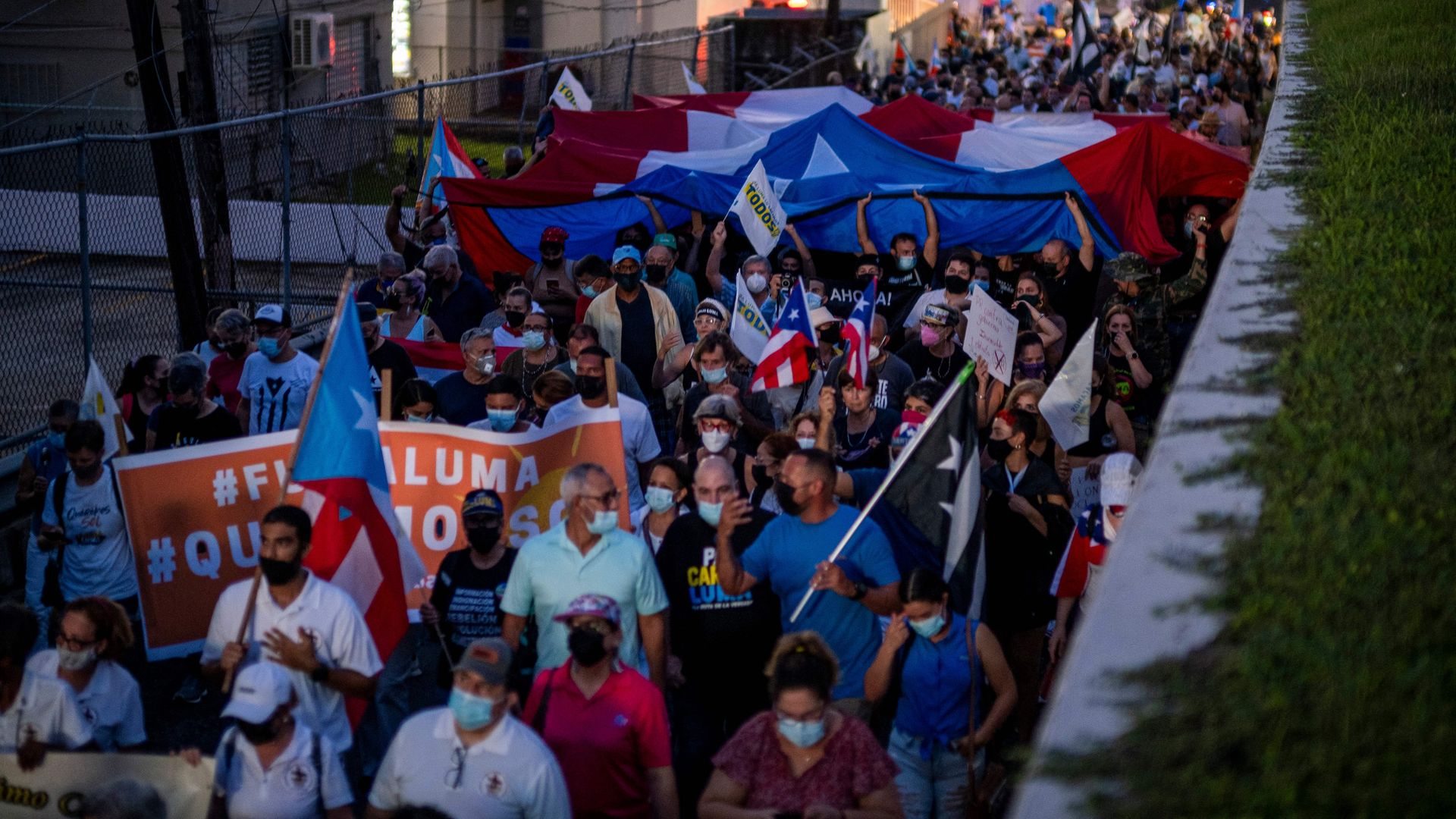 People march along Las Americas Highway to demand the expulsion of power company Luma amid a continued lack of electricity across the island, in San Juan, Puerto Rico on October 15, 2021.