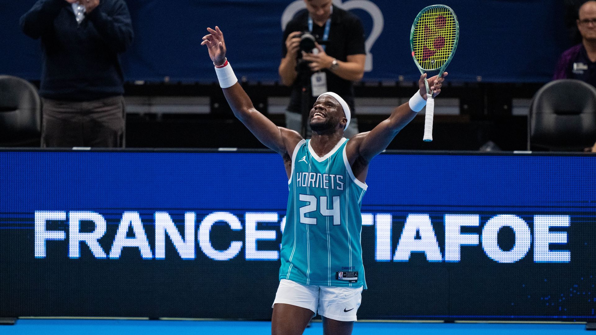Frances Tiafoe wears a Hornets jersey at Spectrum Center during the Charlotte Invitational.