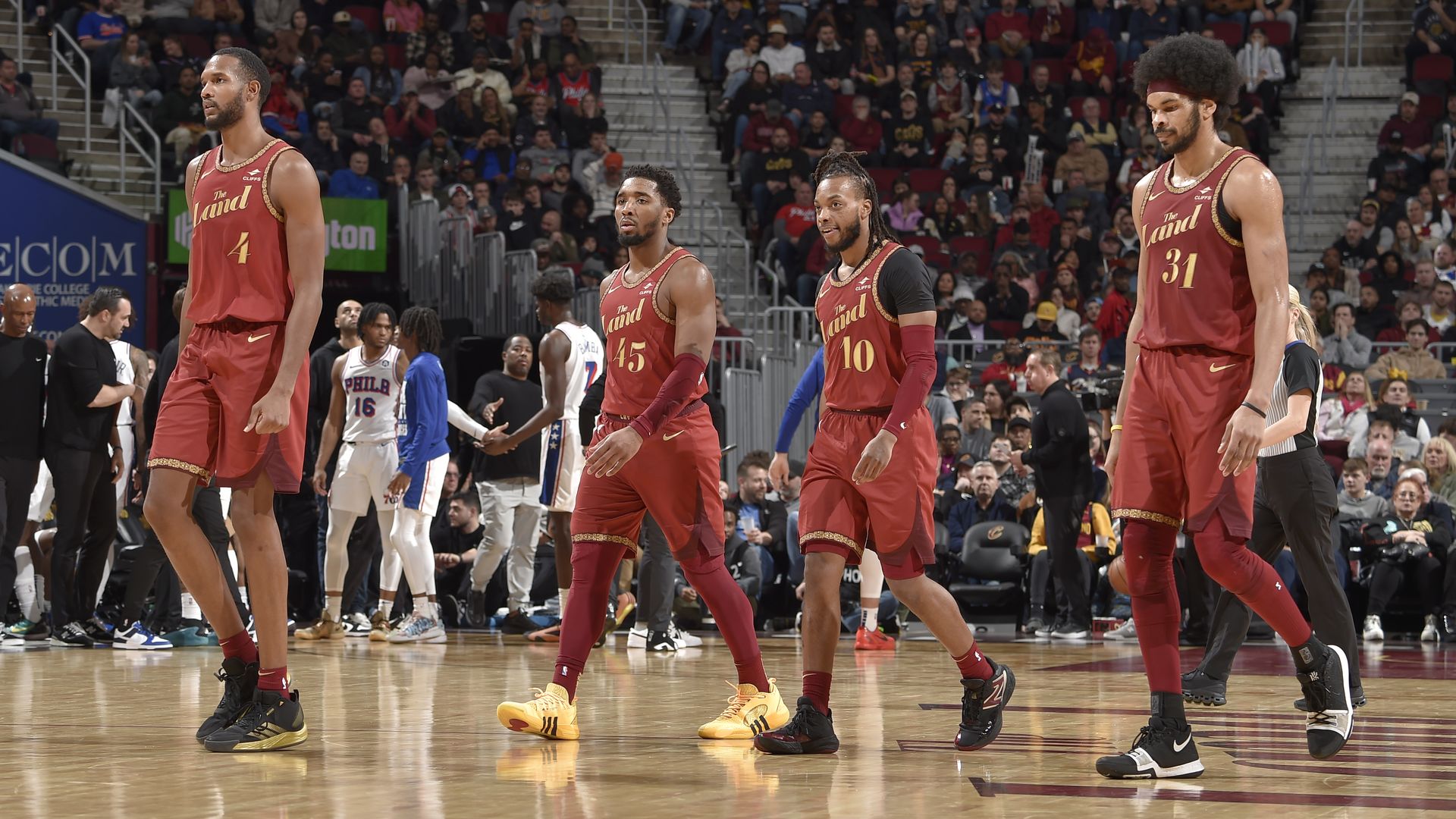 From L-R: The Cavaliers' Evan Mobley, Donovan Mitchell, Darius Garland, Jarrett Allen, walking off court in red jerseys.