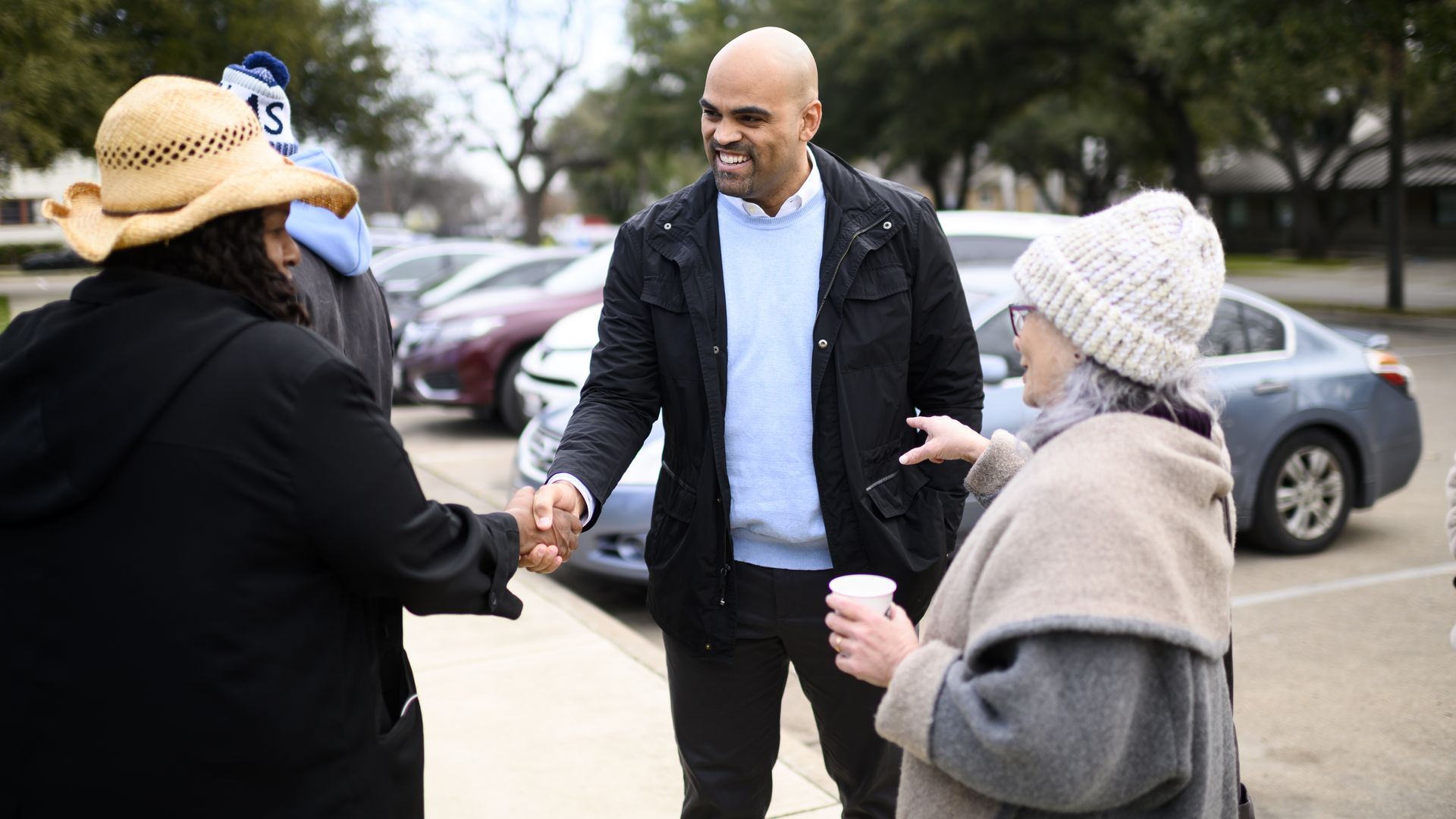 An image of Colin Allred shaking prospective voters' hands.