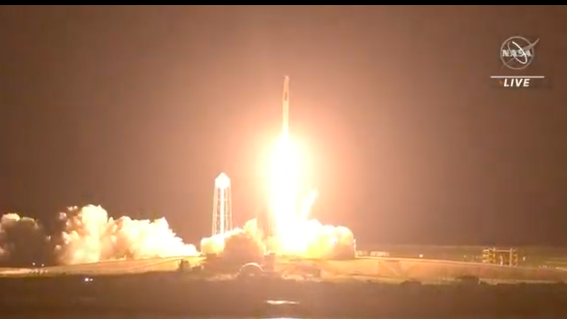 A rocket lights up the night sky bringing astronauts to the International Space Station