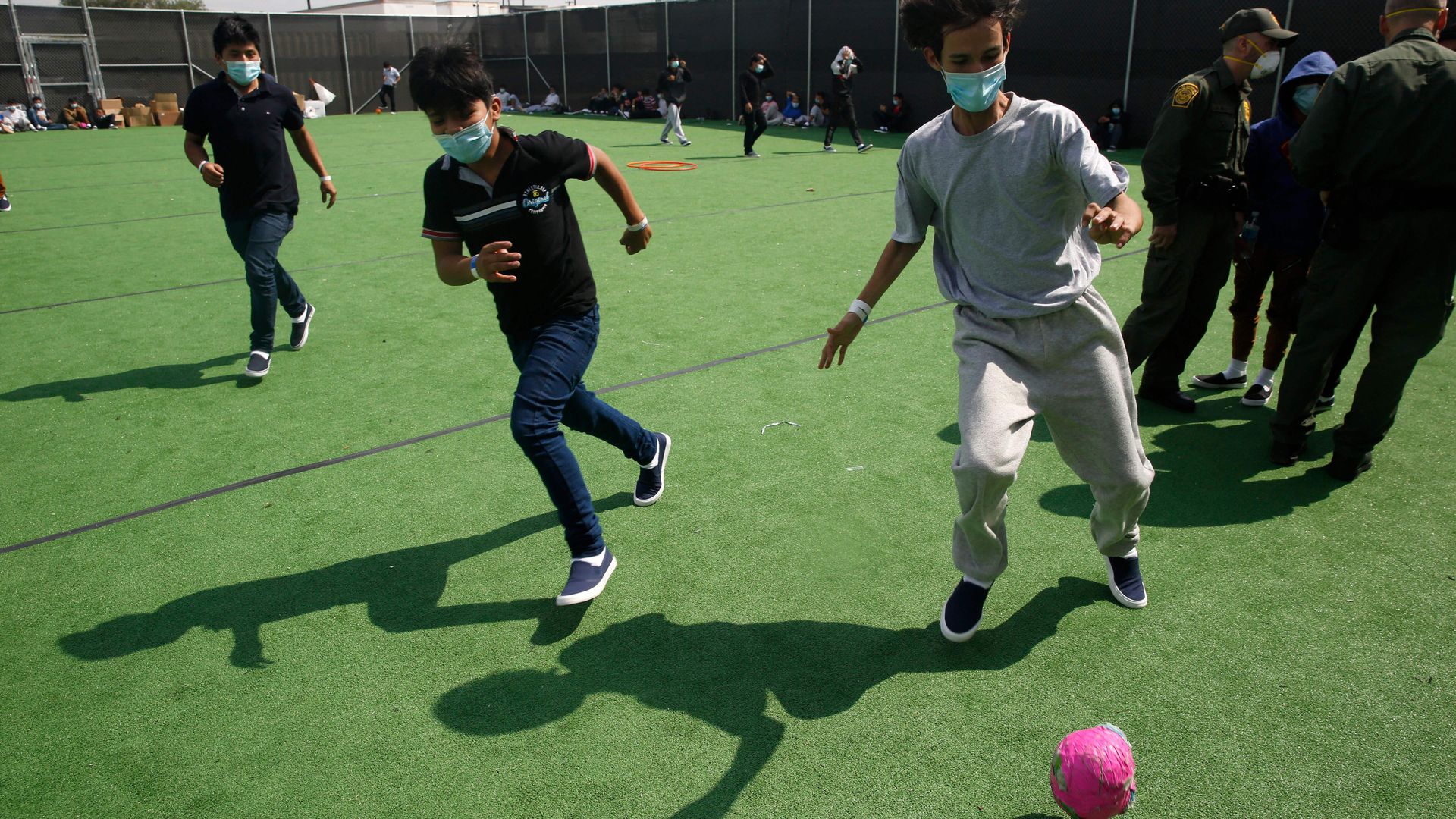 Young minors play soccer at a small field at the Donna DHS holding facility
