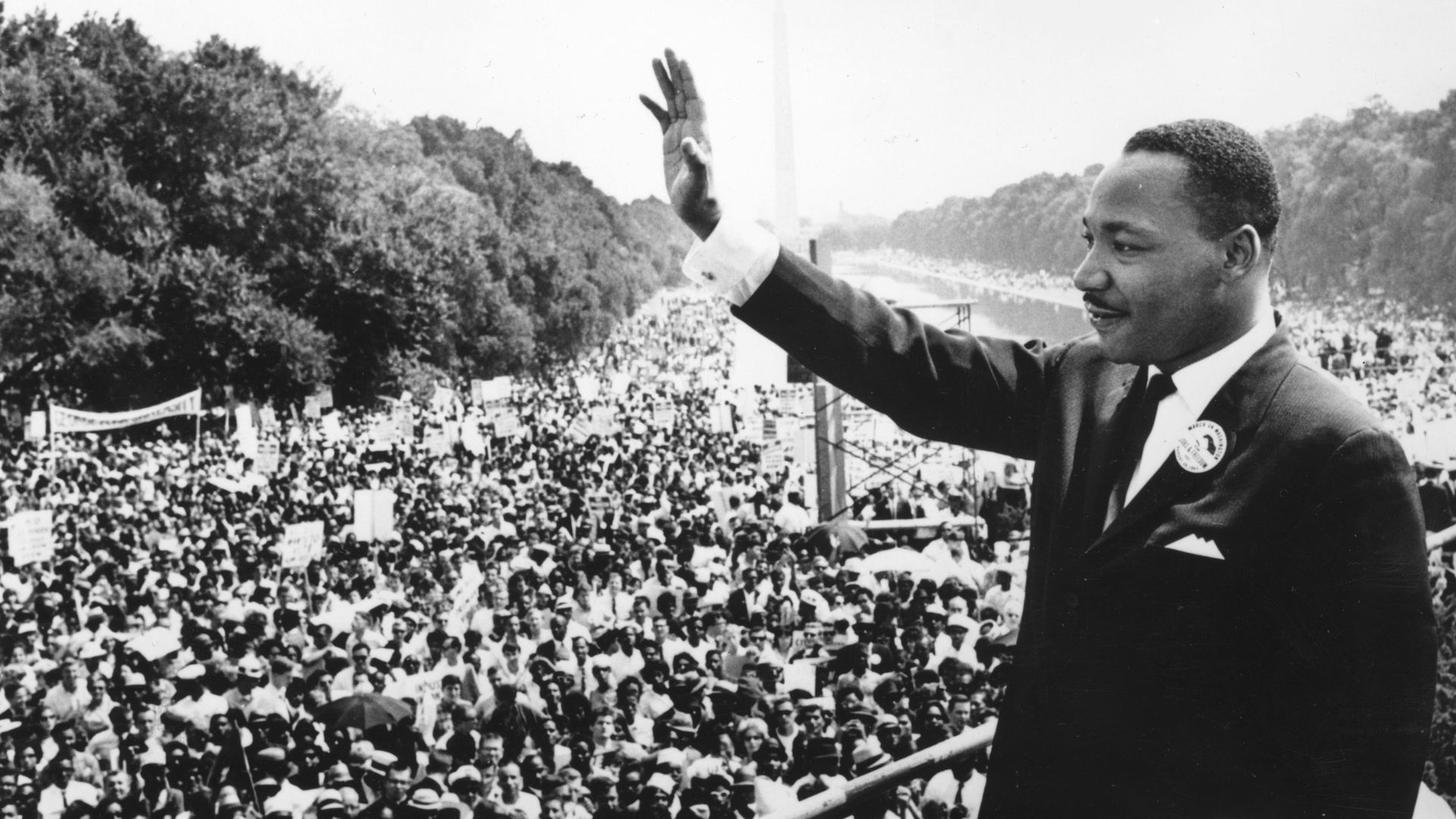 Martin Luther King Jr. waves to a crowd after giving his "I Have a Dream" speech in a historic black-and-white photo