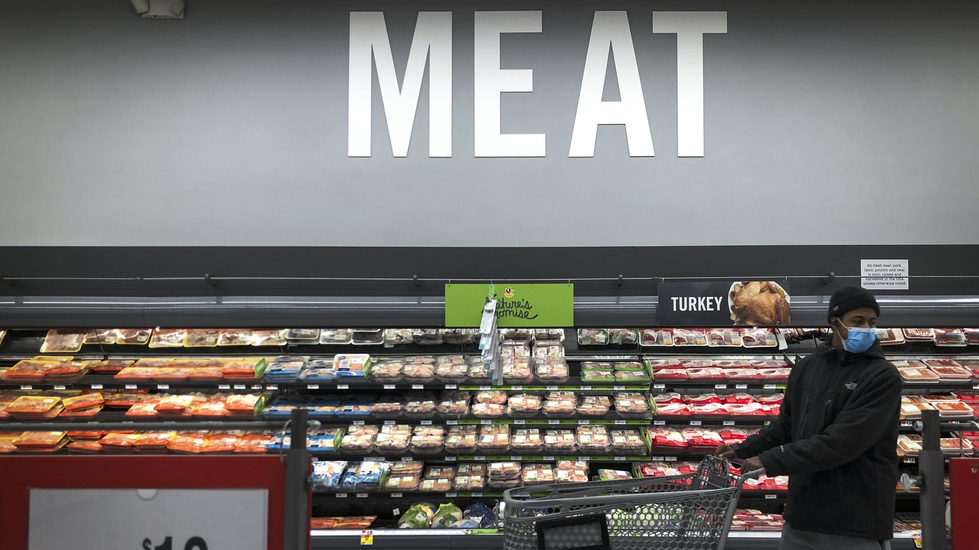 Picture of a super market aisle that says "meat"